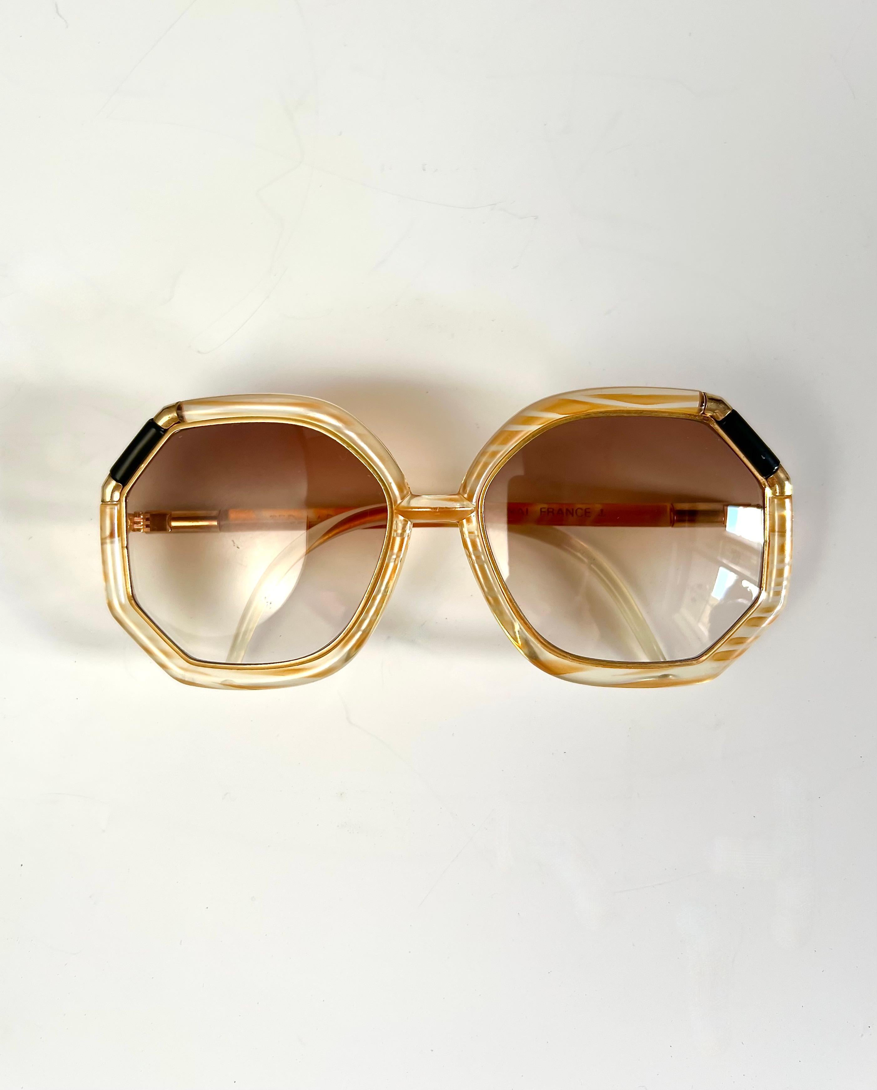 Rarissimi Occhiali Vintage Ted Lapidus Paris Oversize con montatura trasparente decorata, la forma è ottagonale vi sono inserti neri e le finiture sono in metallo dorato. Lo stato è pari al nuovo ma le scritte in oro nelle stanghette sono