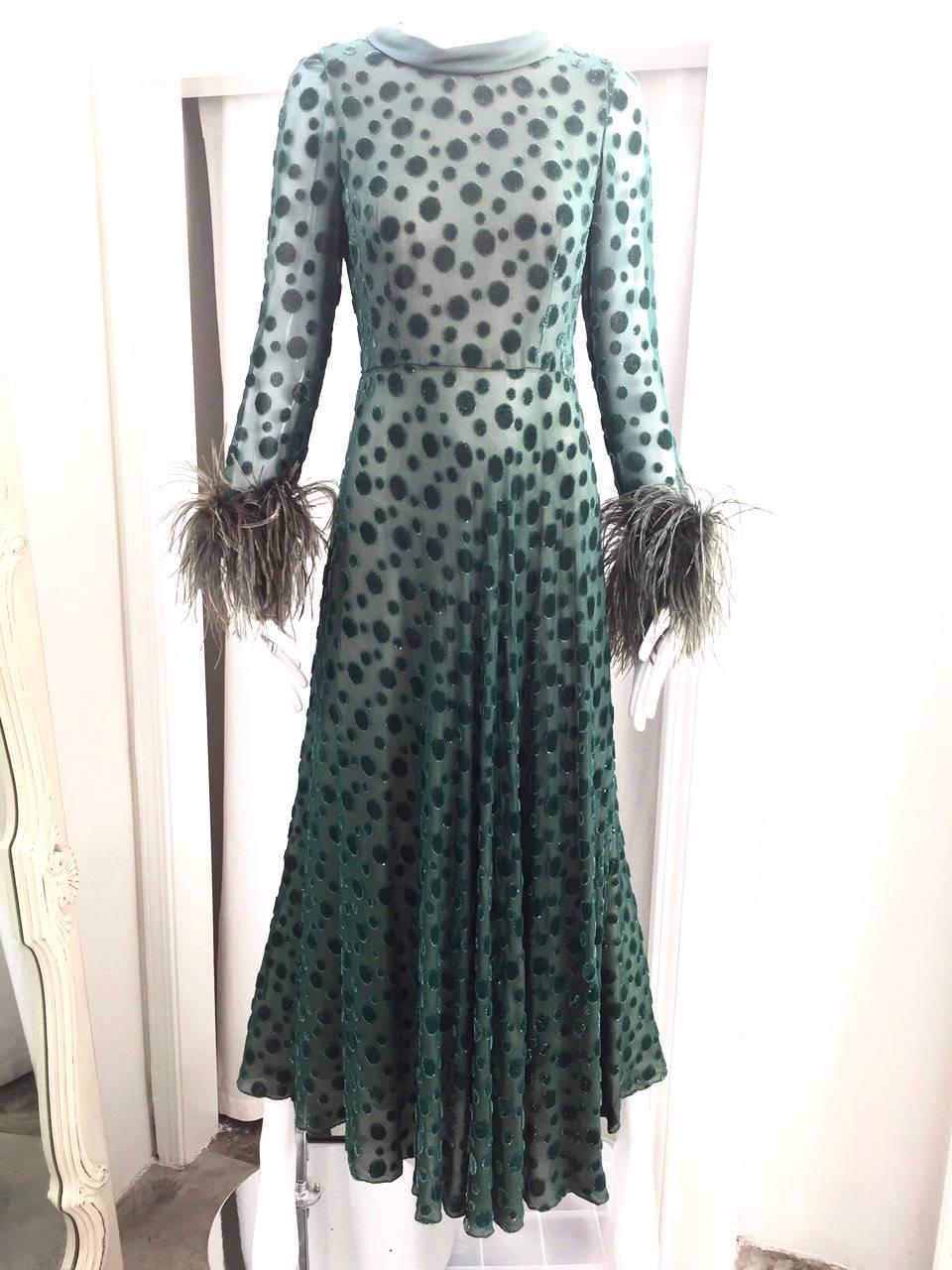 This 1970’s green Cardinali maxi dress is made of silk chiffon with irregular green velvet dots.  The mocha lining shows thru the silk chiffon to create a wonderful texture, and the ostrich feather cuffs add a glamorous touch. 
Size: