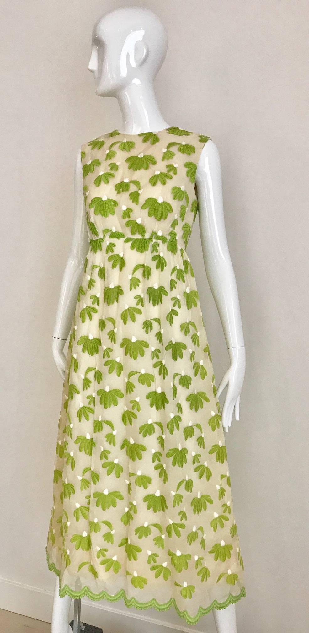 Vintage 1960s Bob Bugnand creme and green leaf sleeveless heath Dress. Zip at the back. Dress is fully lined.
Size: SMALL 2-4
Bust: 32 inch  / Waist: 26 inch  / Hip: 40 inch ( lining) outer fabric is 46 inch
Dress length: 48 inch

***Small tear