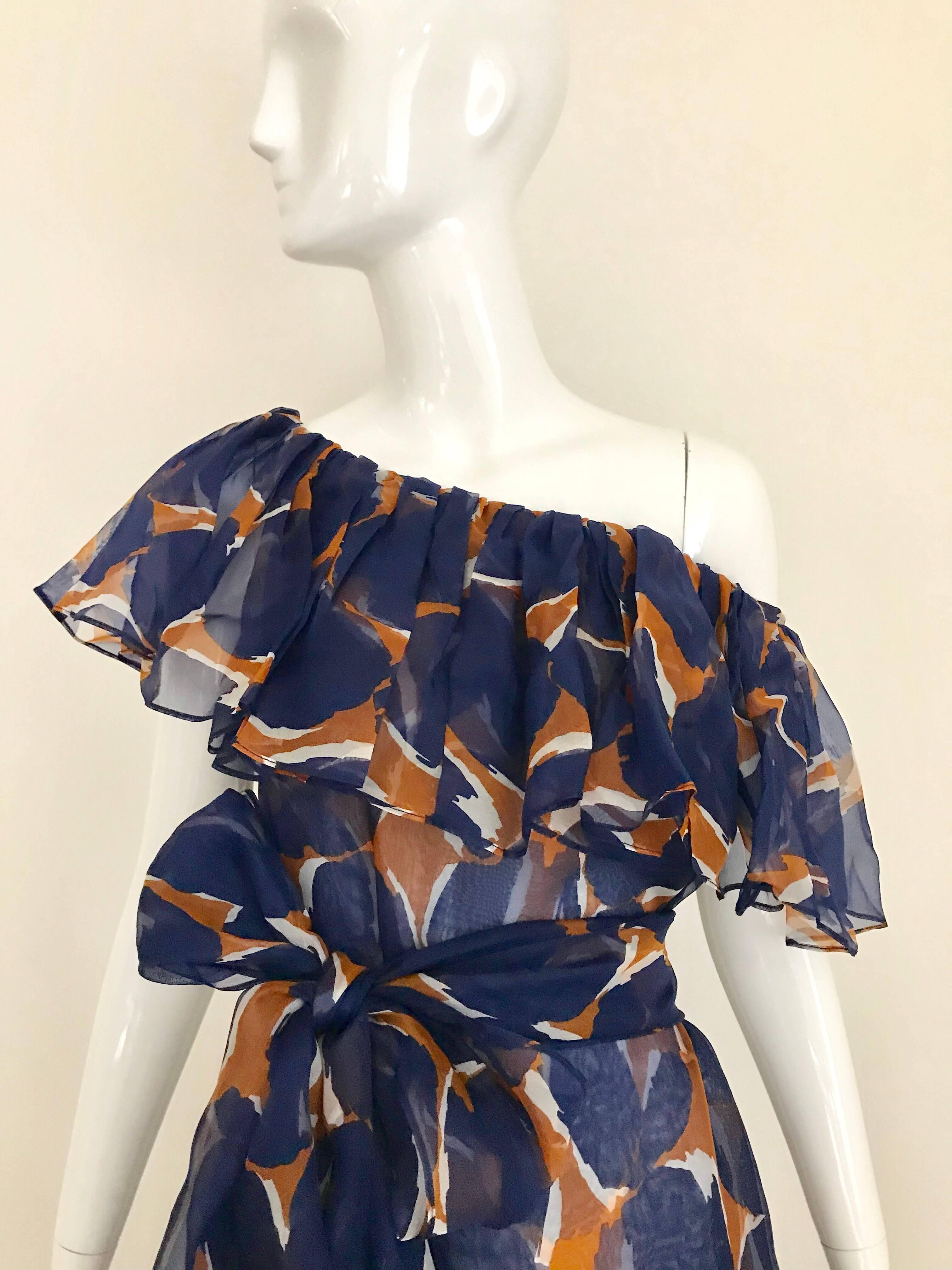 This late 80s  Saint Laurent rive gauche silk organza dress has the influence of a classic Flamenco dress but with much more subtle ruffles.
This print contains a blend of navy blue, light brown and white that creates a calm understated feel. The