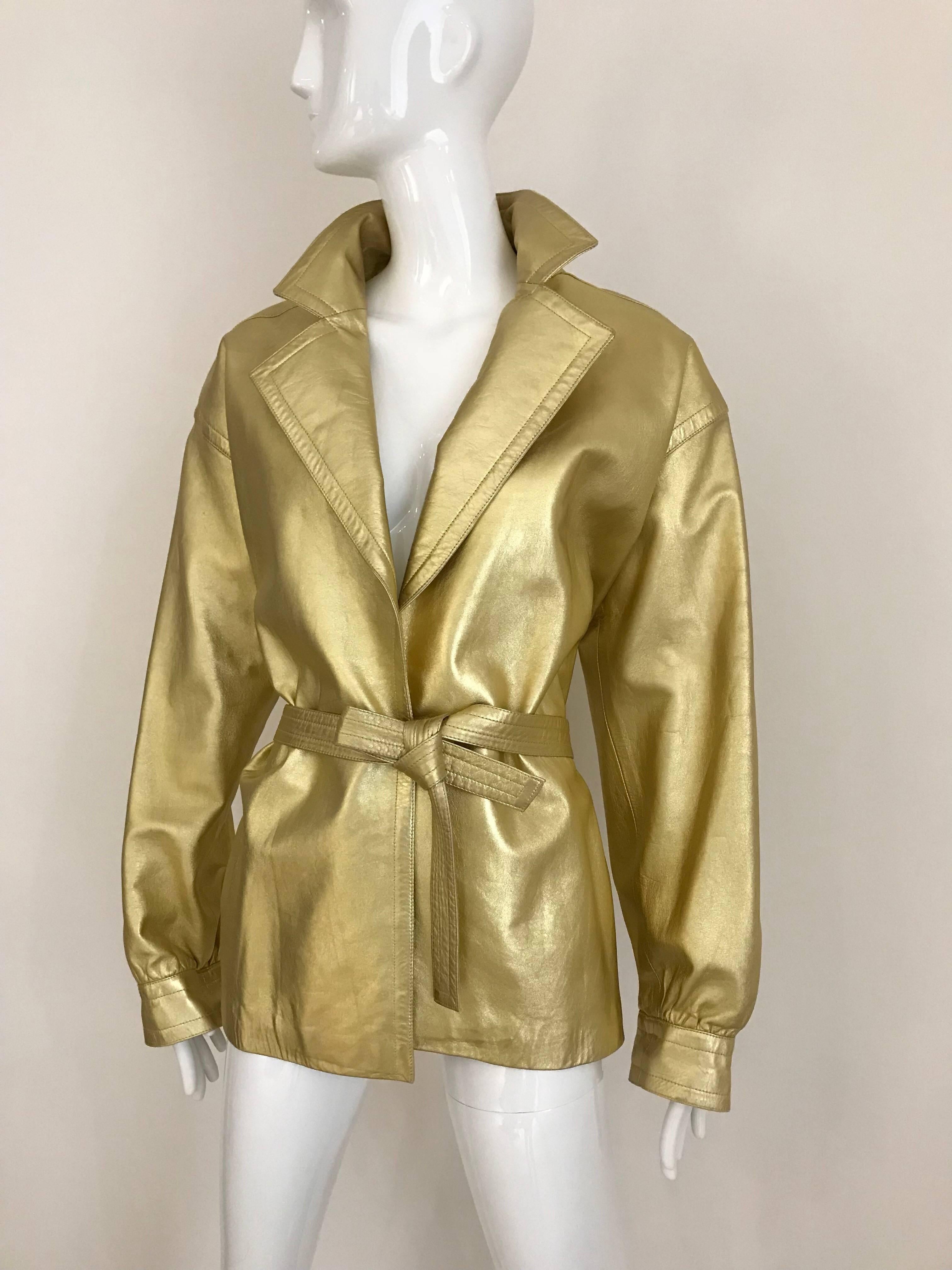 Diese rive gauche goldfarbene Lederjacke von Saint Laurent verkörpert klassisch guten Look und Stil. 
Es gibt keine Verschlüsse:: aber ein dünner goldener Ledergürtel schließt das Kleidungsstück. 
Jacke aus den 80ern mit Schulterpolstern. 

Es ist