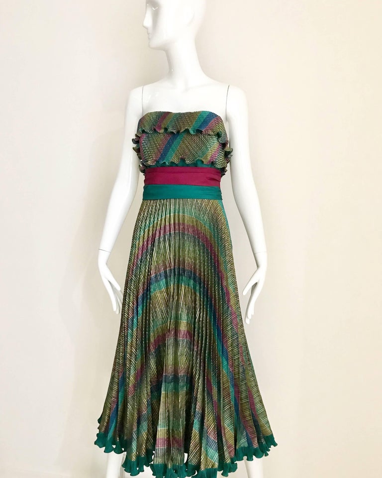 This 80s Frank Usher dress is barrel of fun! The strapless design combines a rainbow color palate with full pleating, and the dress is edged with a ruffled hem.
There is a sash-like design that slims your waist and contrasts the movement of the