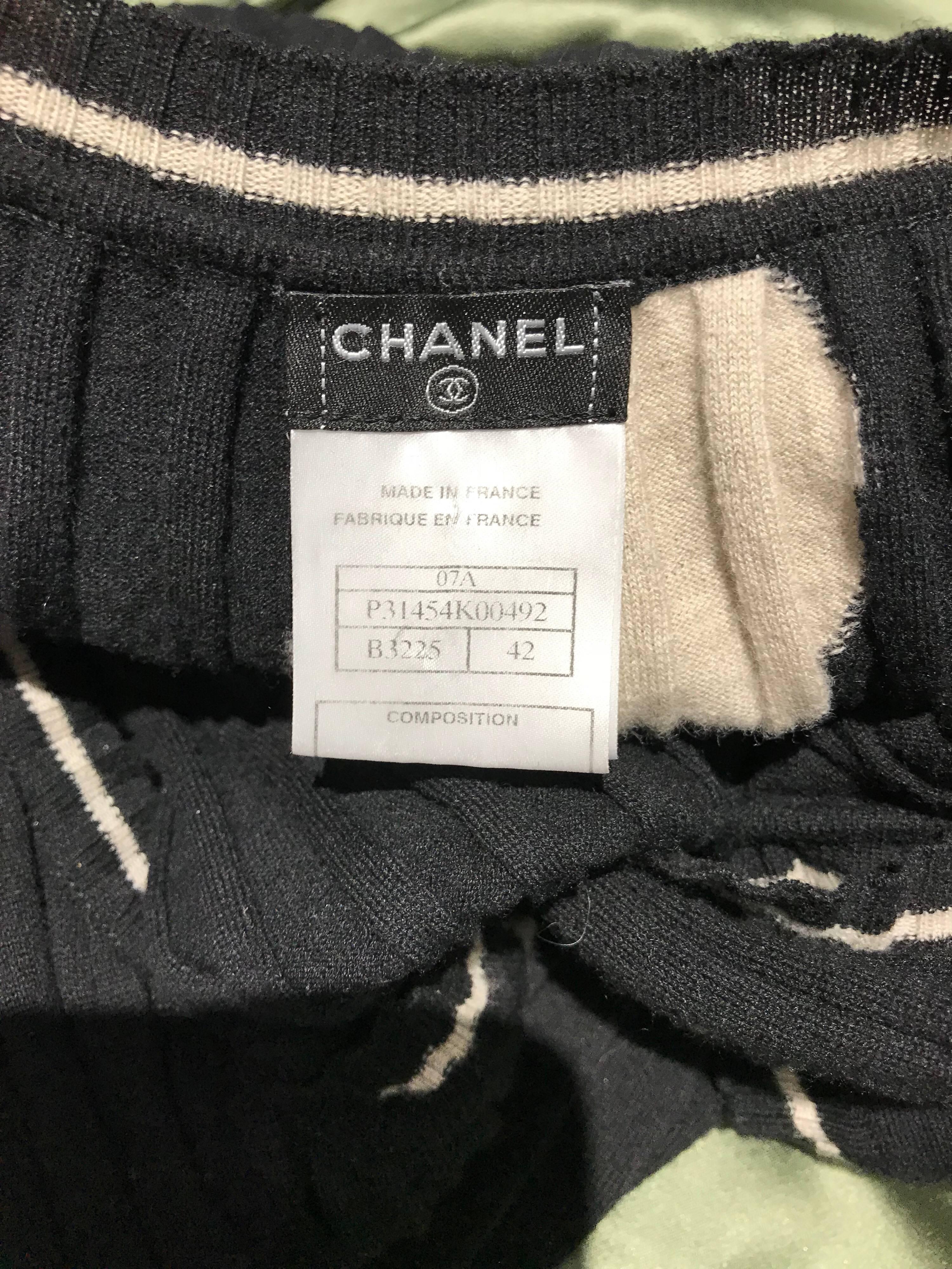 Chanel Schwarzes und cremefarbenes Kaschmir-Strickkleid mit Cap-Ärmeln
Markiert Größe 42. Passform US 4/6 Small- Medium
