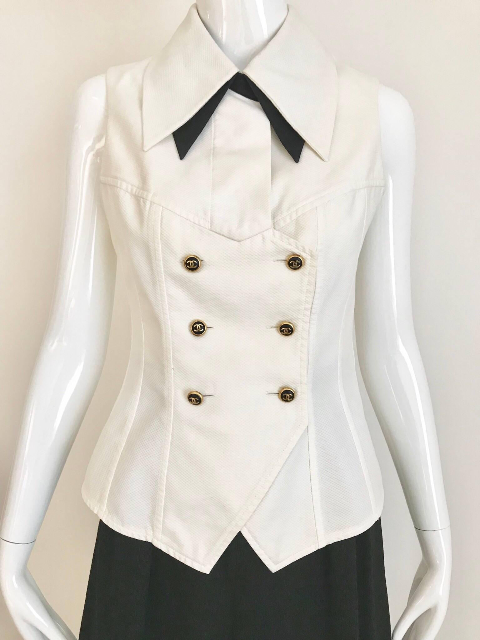 Chic vintage white cotton Chanel sleeveless vest top and black silk tuxedo pant suit set.
Chanel Top/Vest: Bust: 32 inches/ Waist: 26.5 inches/ Hip: 34 inches
Chanel Pants: Waist: 25 inches/ Hip; 39 inches/  Inseam: 30 inches/ Lenght: 43 inches