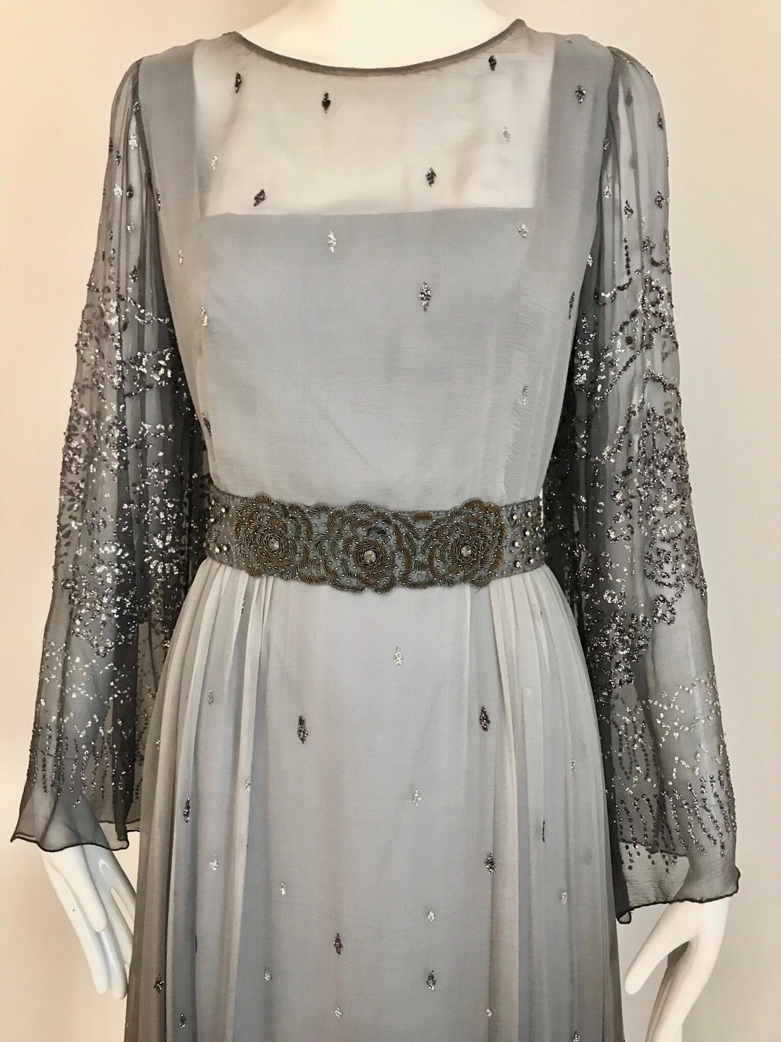 Beautiful 1970s Richilene Grey Silk chiffon Dress with silver sparkles appliques all over bodice and skirt. Romantic and perfect for wedding event or summer evening party. Dress come with grey silk ribbon sash with embroidered beads.
Size: