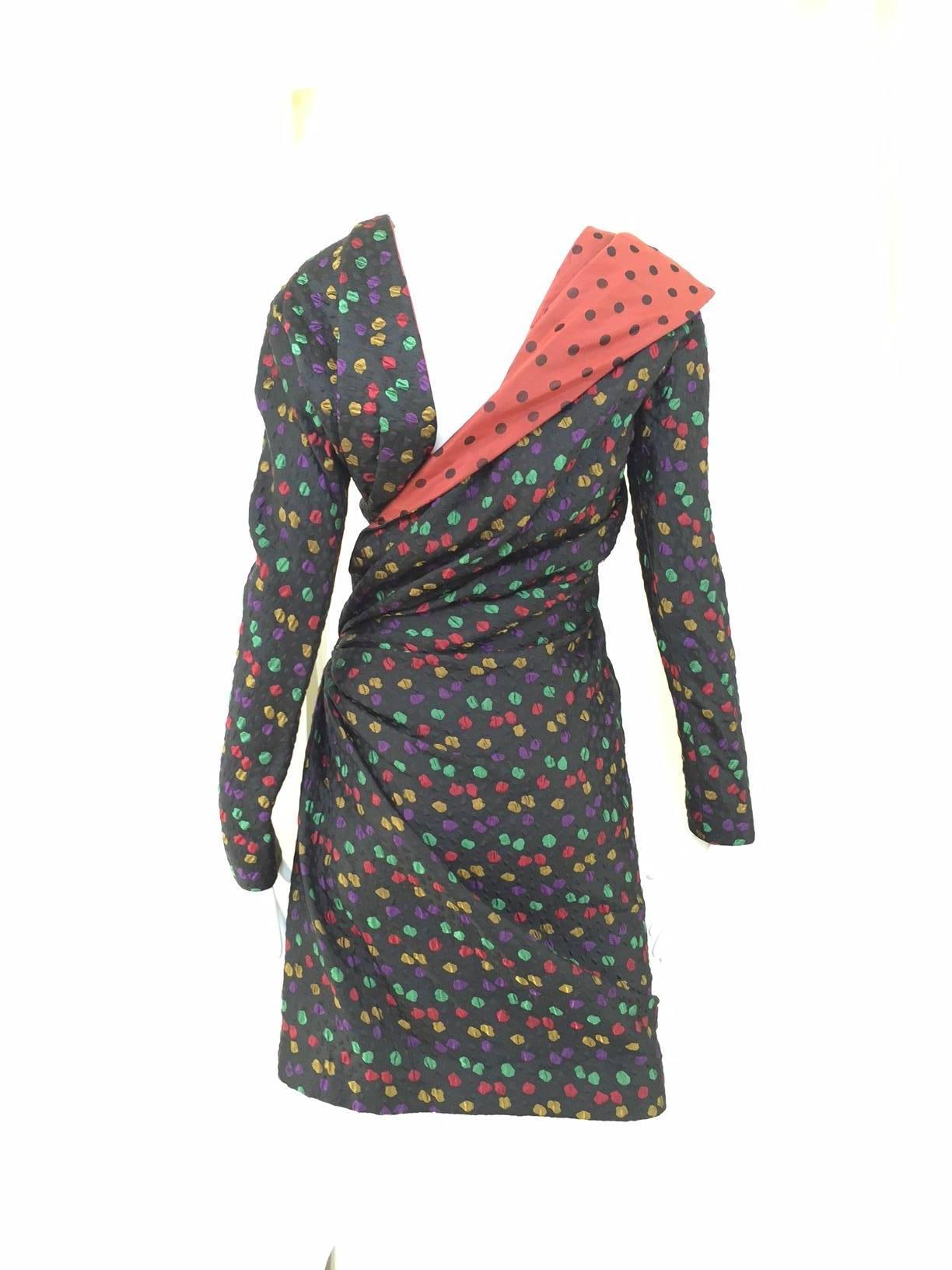 Rare 1980s Givenchy haute couture black silk matelassé cocktail dress with asymmetrical neck line with multi color, irregular shaped dots in yellow, red, purple and green.  On the front of the dress there is diagonal ruching across the bodice to the