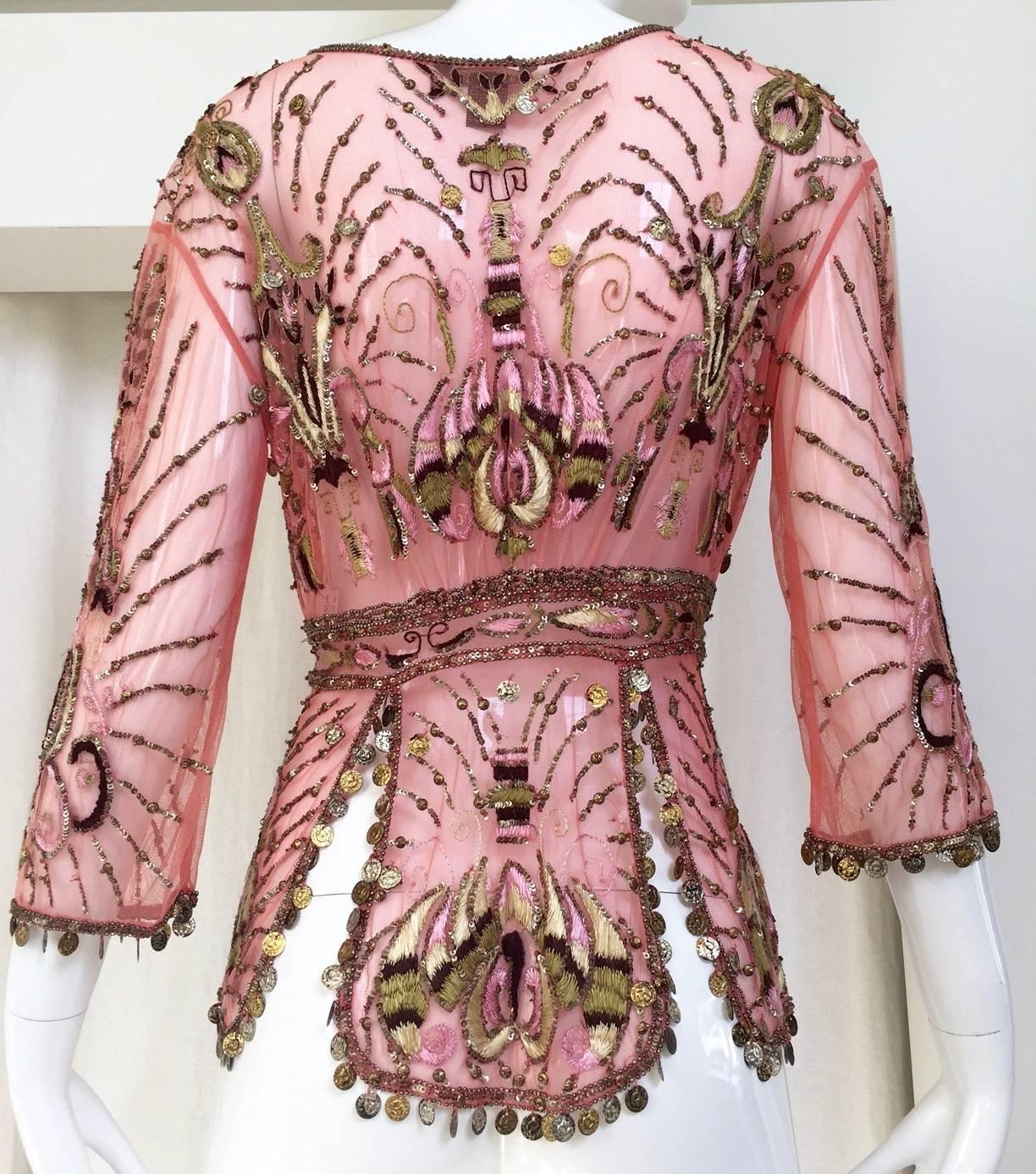 Beautiful Roberto Cavalli embroidered mesh beaded silk cardigan in salmon pink. Three quarter length sleeves. cardigan/blouse has tie closure. gold charms on the sleeves and at the bottom trim of the blouse.
Size: 4
Shoulder: 16