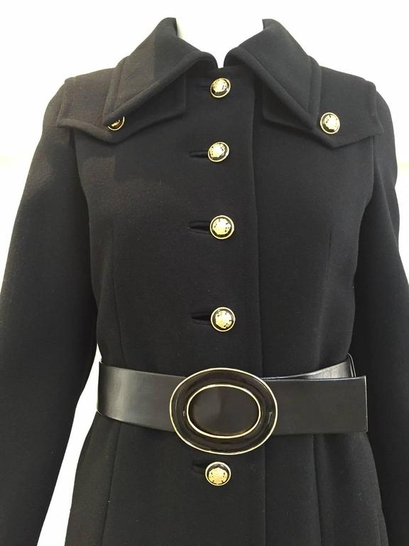 1970s black Bonwit Teller wool crepe pea coat with black and gold metal crest button. ( belt - side pockets).  size: 2 or 4 max.
Bust: 34