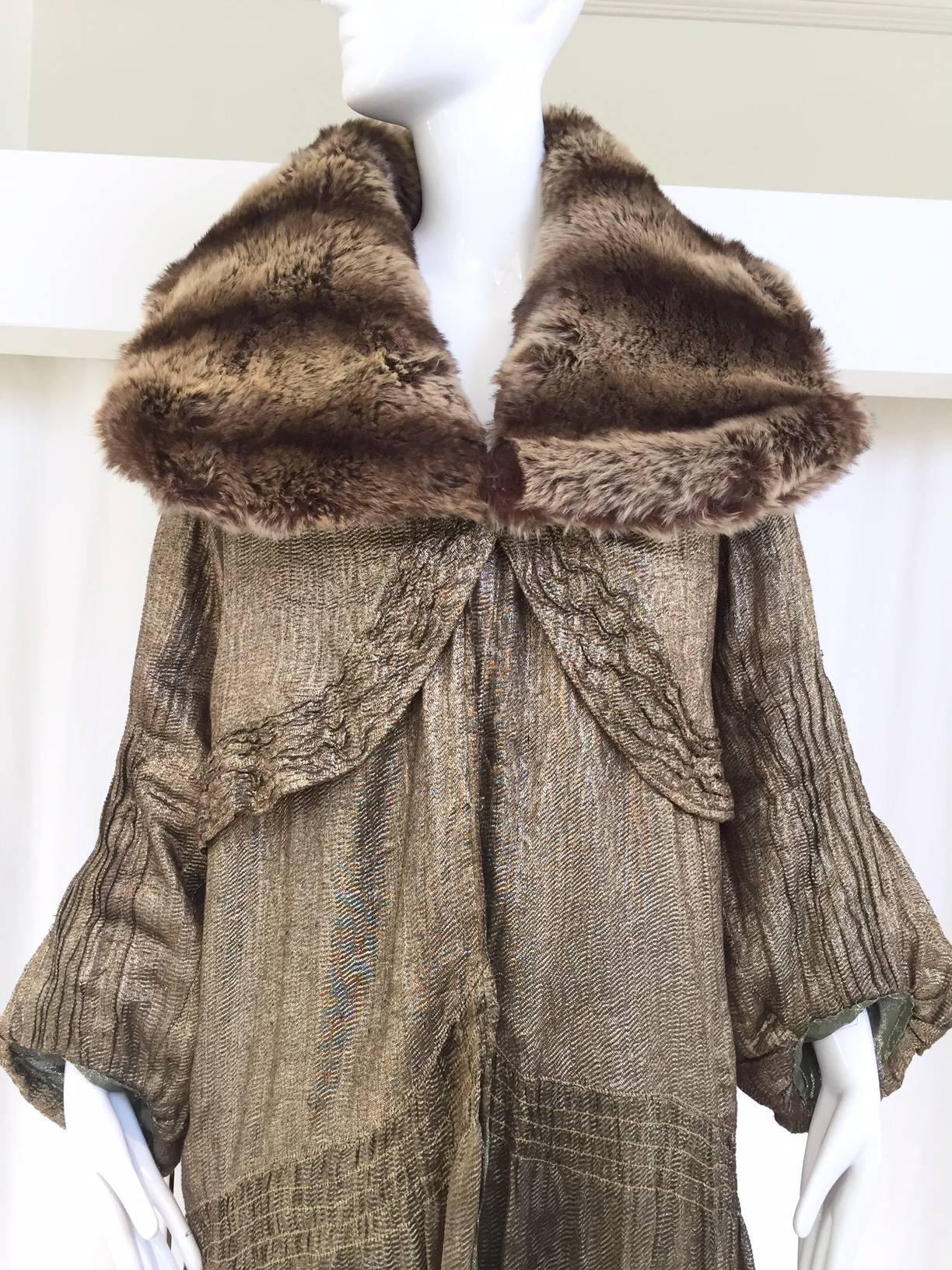 1920s silk lame opera coat with faux fur collar. Lining has been replaced. 
Fit size 4/6/8
