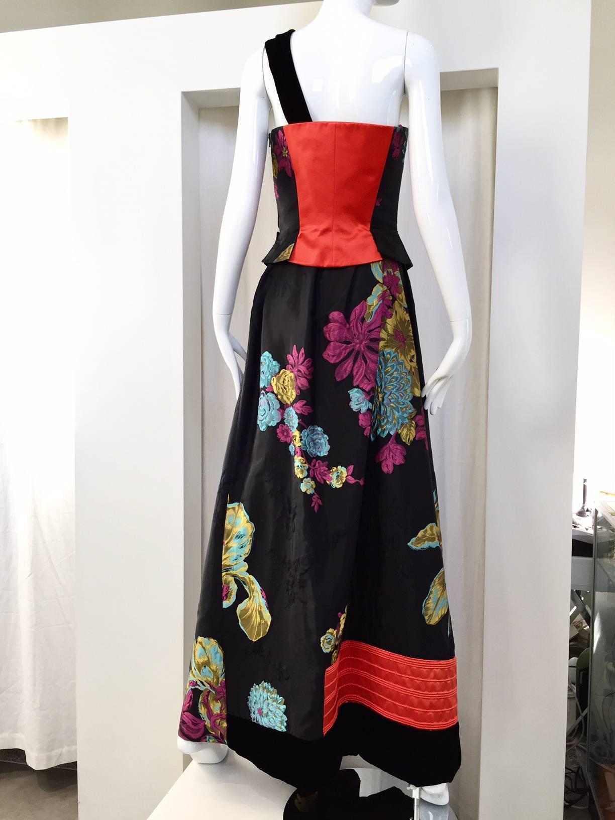 This Vintage Christian Lacroix  bustier and skirt set is an exquisite combination of color and textures.  The vibrant colors in the floral print are highlighted against the black silk fabric and offset further by subtle 