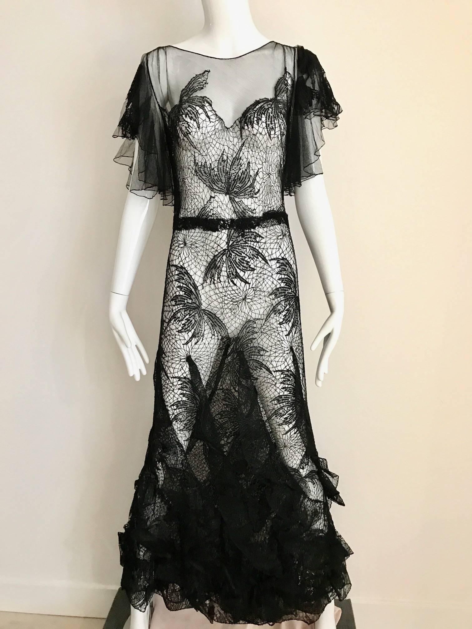 This Dramatic and Beautiful 1930s black lace evening gown is really impeccably made. Cobweb lace throughout the dress and flutter sleeves. Cascading ruffle trough the hem. Lace is strong and in Excellent condition except for small tiny tear  see