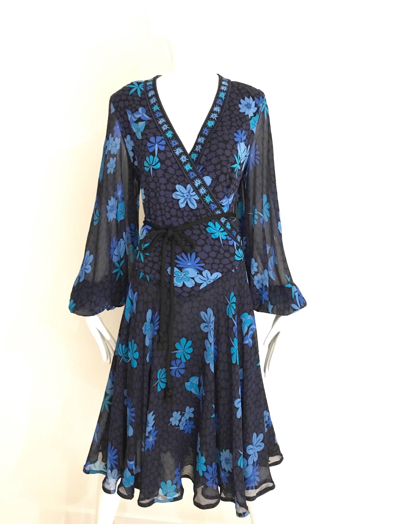 Vintage 1970er Bessi schwarzes leichtes Jersey Kleid in hellblauem Blumendruck V-Ausschnitt Kleid mit gewellten Ärmeln. Das Kleid ist mit Seide gefüttert und wird mit einem schwarzen Jersey-Kordelgürtel geliefert.

Brustumfang : 44