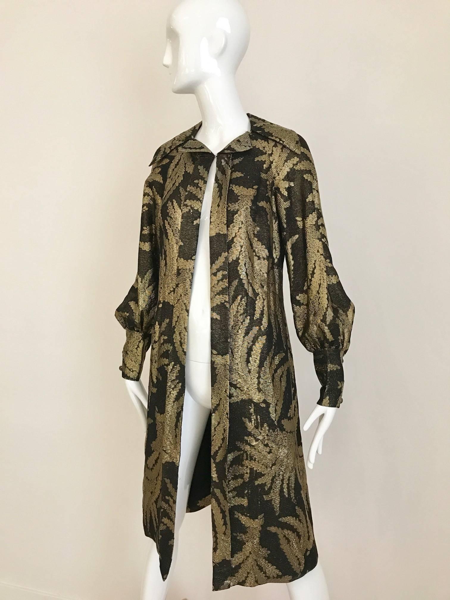 This vintage 1970s Pauline trigere light evening coat has a combination of black silk brocade and gold theread describing a leaf design troughout. The 5