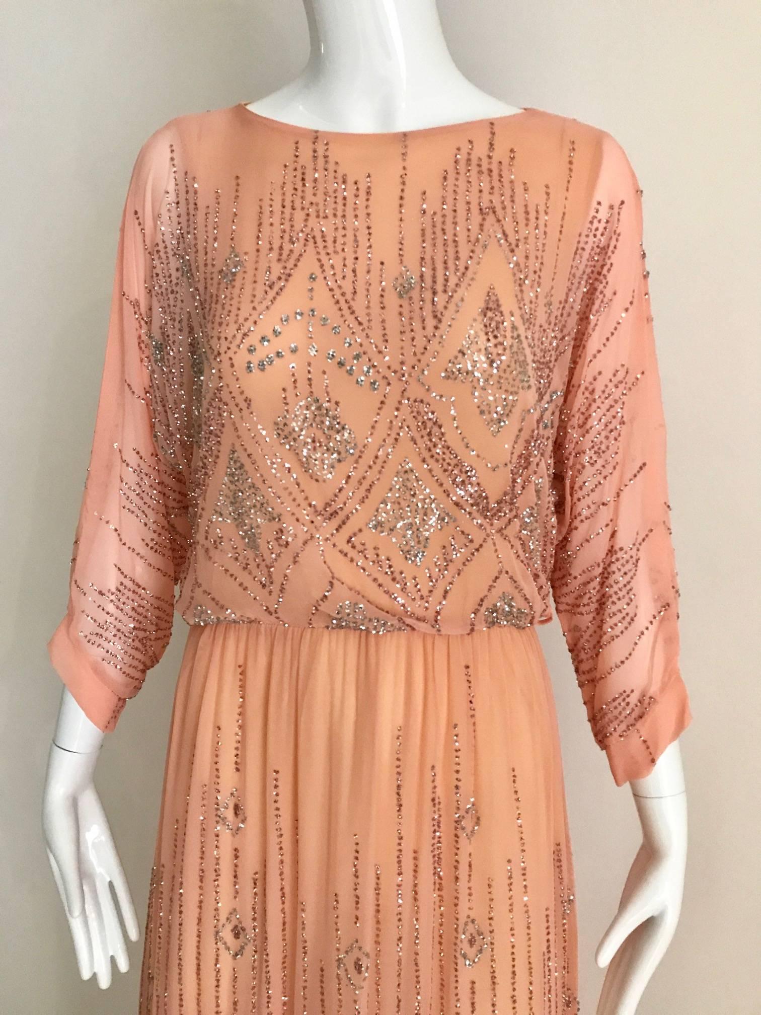 Vintage 1970s peachy pale pink crepe maxi dress covered in metallic glitters. Dress was sold in Saks Fifth ave boutique and dress is made in france. Elastic waist and slip on dress. Glitters color is in silver and almost redish mauve. 
Size:
