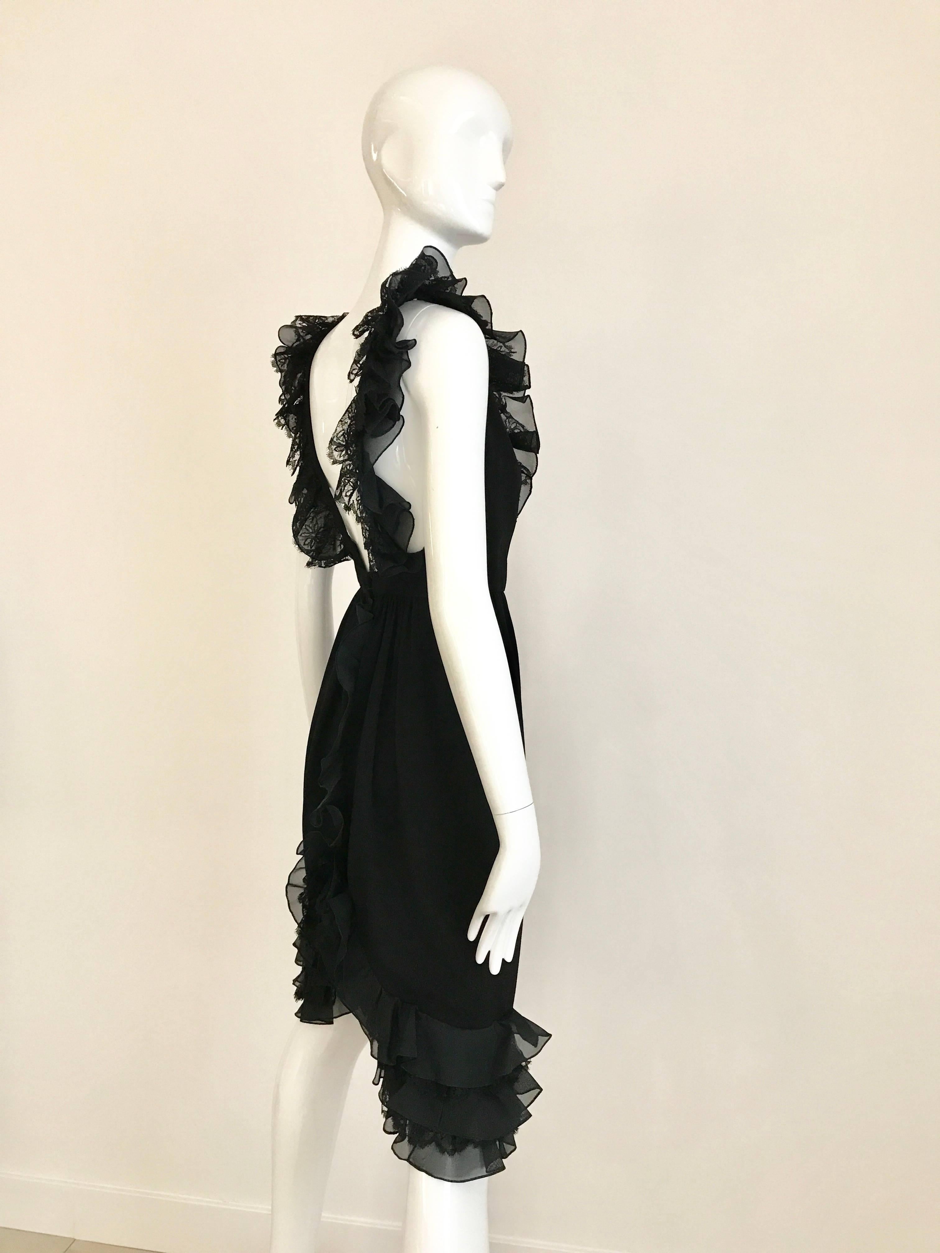 Sexy and chic Vintage Bill Blass 1980s little black  crepe dress with ruffle V neck line and exposed back. This dress is trimmed in rows of black organza and lace ruffles. The dress has a low scooped neckline edged in ruffles down the front and a