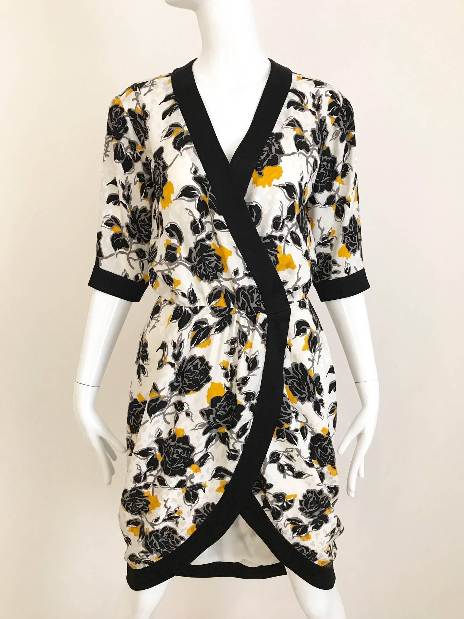 1980s vintage Yves Saint Laurent white, black and yellow rose print silk wrap summer dress. Black silk piping on the sleeves and V neck collar. Hook an eye fastener. 
Dress is styled with vintage Judith leiber adjustable leather belt with star