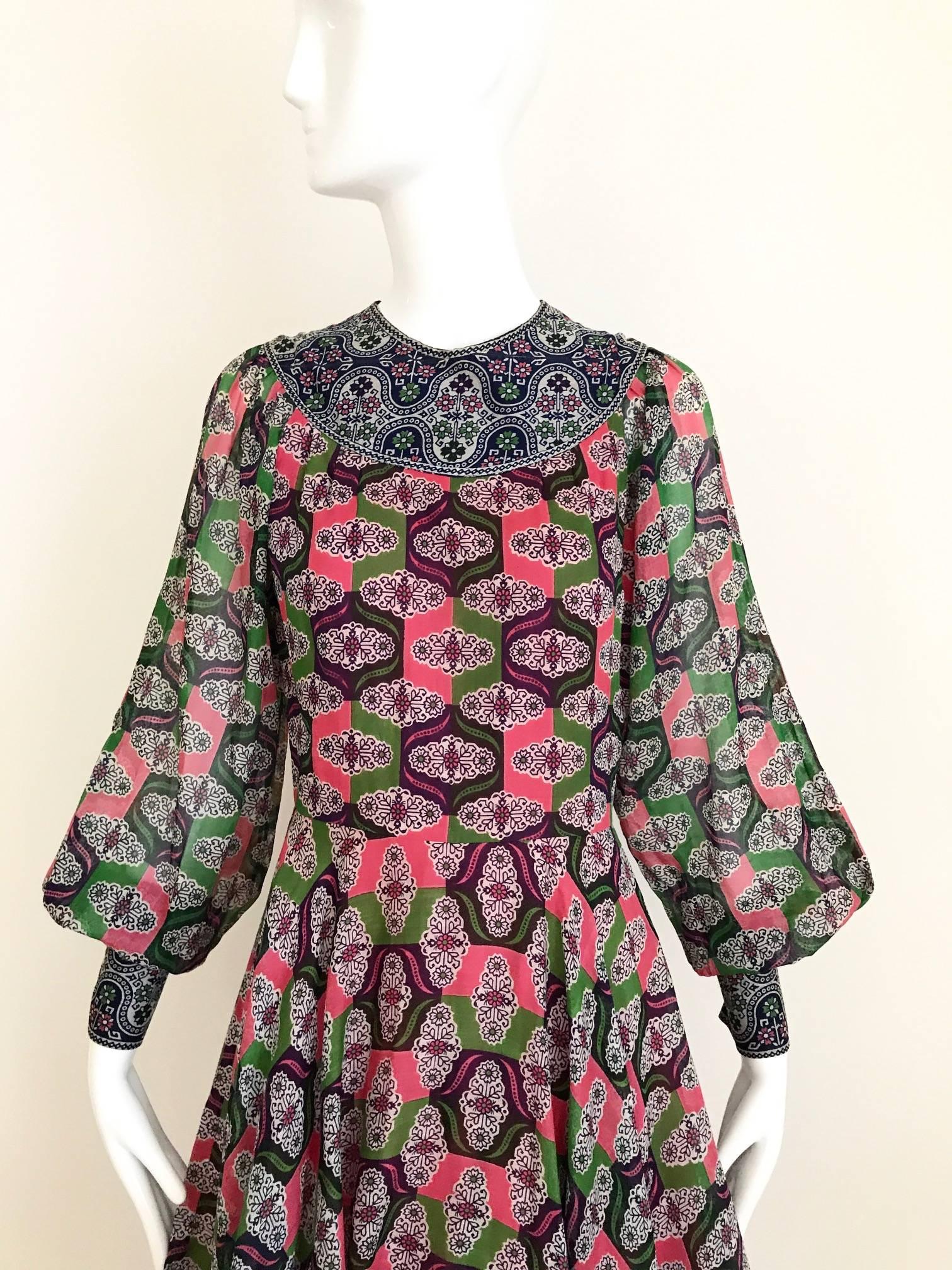 Beautiful 70s vintage ethnic Indian geometric print, purple, pink, green and blue cotton print dress has billowy sleeves with long snap button cuffs with flair skirt. Dress is lined in cotton.
 Measurement:
Sleeve length: 27 inches / Bust : 34 inch