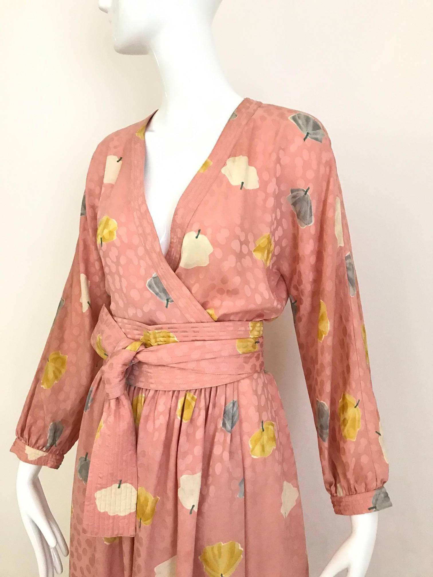 Chic Vintage Adele simpson light pink silk jacquard wrap dress with wide obi style belt. Dress has Ginkgo leaves print in yellow, grey and white. 
Measurement: 
Bust 34 inch  / Waist: 24 inch to  25 inch ( hook an eye can be moved)
Hip 44 inch /