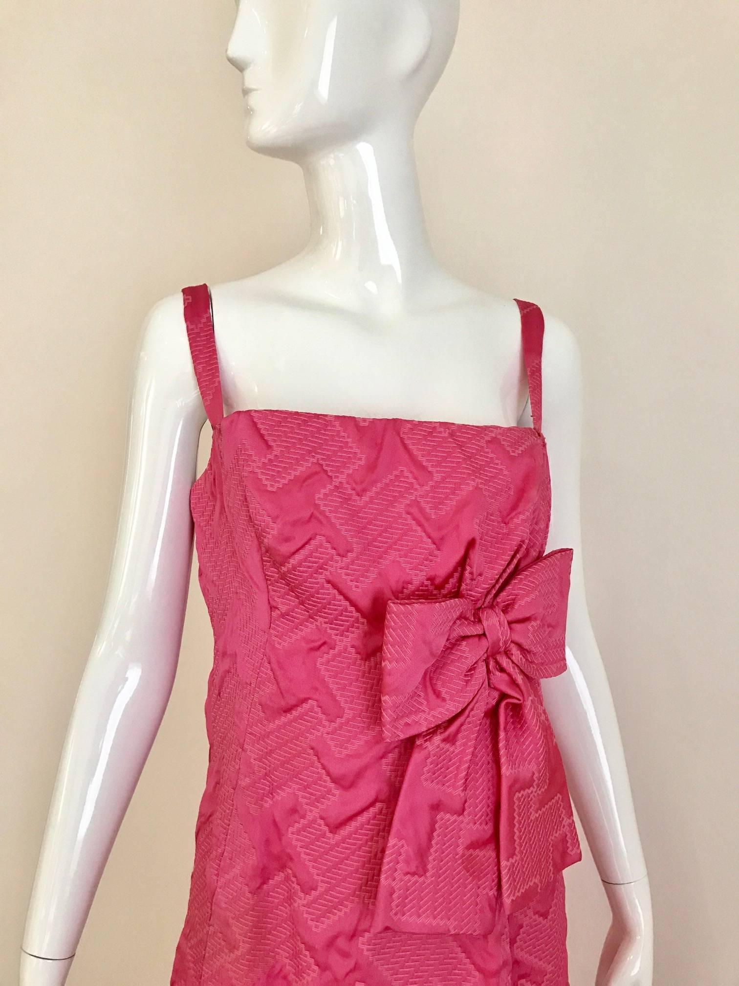 Vintage  Late 1960s  and early 1970s Magenta pink satin brocade gown .
Bright pink textured and quilted satin fabric. Slim fitted style with spaghetti straps, and a long straight skirt with offset pleat in front and back and has the big bow accent. 