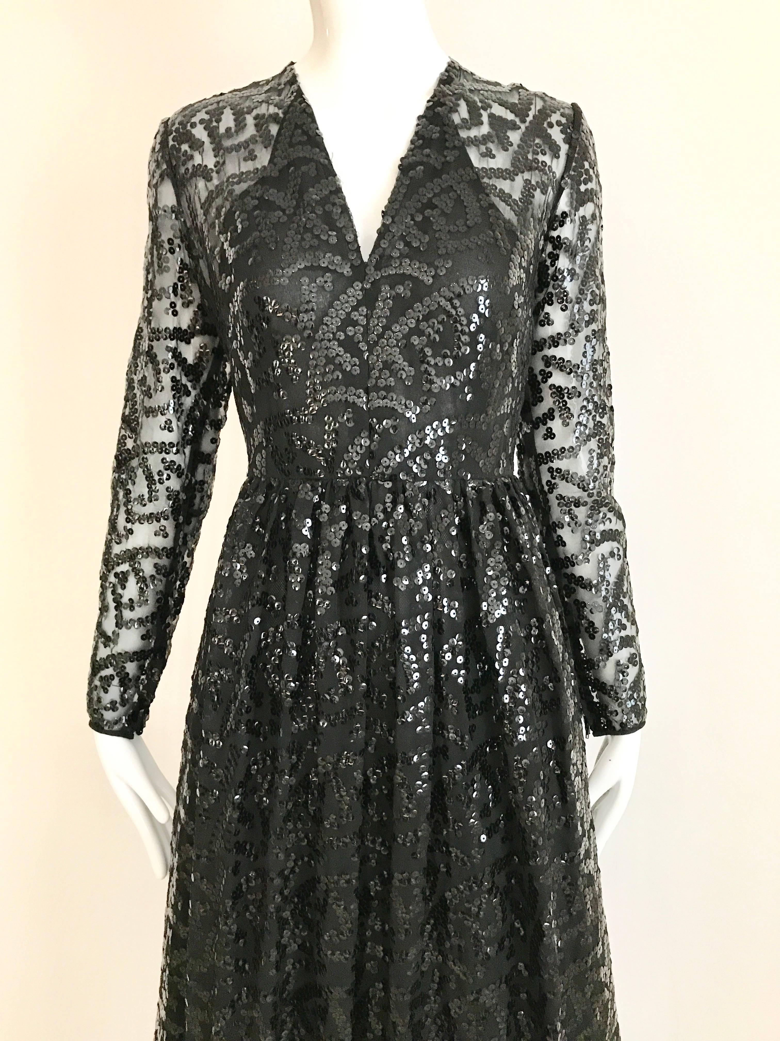 1970s Bill Blass black sequin V neck long sleeve dress with black ostrich feather hem. Semi Sheer Sleeves, and fitted in the waist. Perfect for Black Tie event.
Size: 4 
Bust: 34 inch / Waist: 26 inch / Hip: 40 inch/ Length: 51 inch/ Sleeve 23