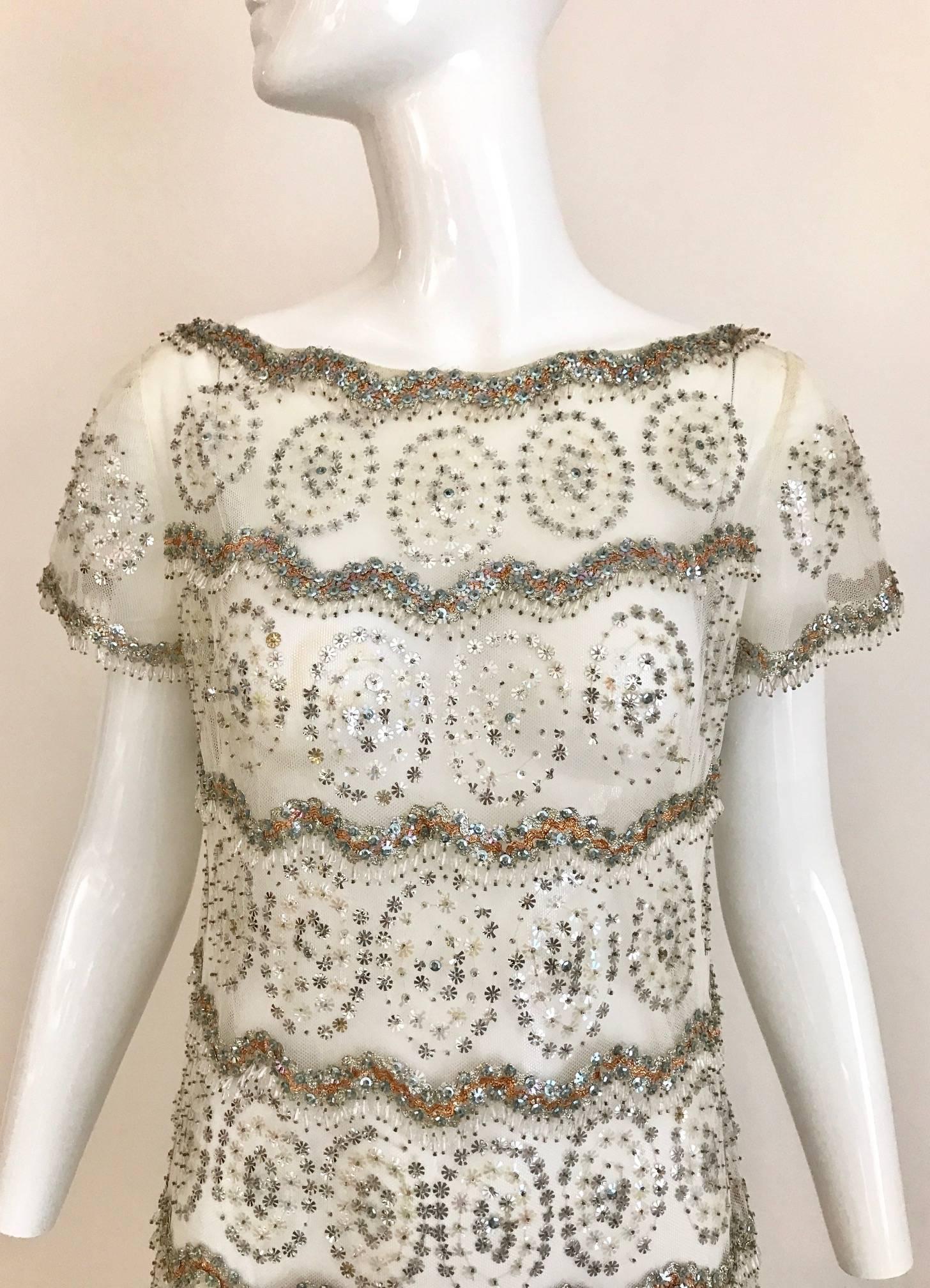 Beautiful Malcolm Starr 1960s White Mesh tulle wedding dress embellished in silver and gold sequins paillettes trough out the dress. 
Dress comes with slip.   Size: Small - Medium
Bust: 36 inch  
Waist: 34 inch
Hip: 36 inch
Length: 55 inch

