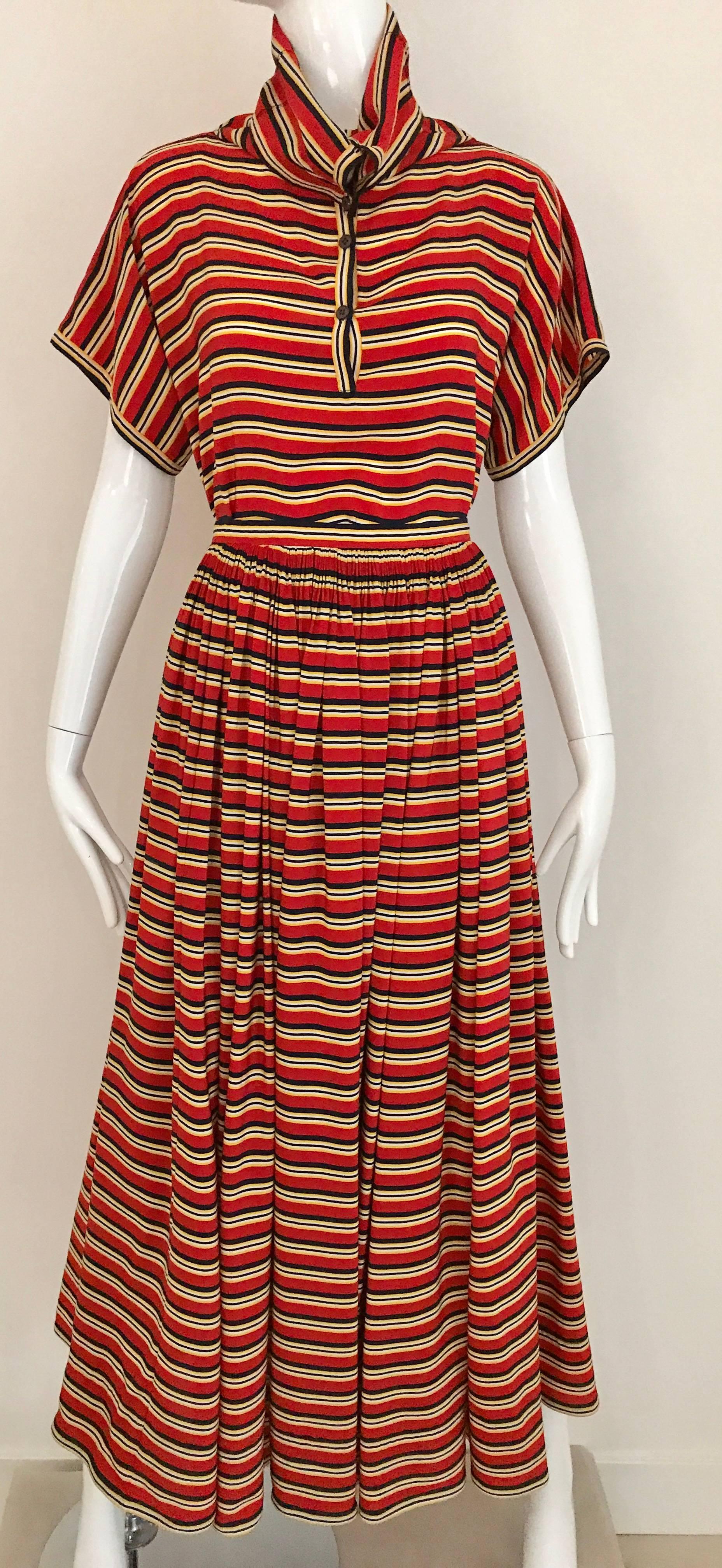 1970s GEOFFREY BEENE Red, Black and Orange multi Striped Silk Blouse and Skirt ensemble. Blouse has button cowl neck that can be worn 2 different way. 
Size: Small
Blouse measurement: Bust: 40 inch / Blouse length: 19 inch
Skirt: 24 inch waist ( you