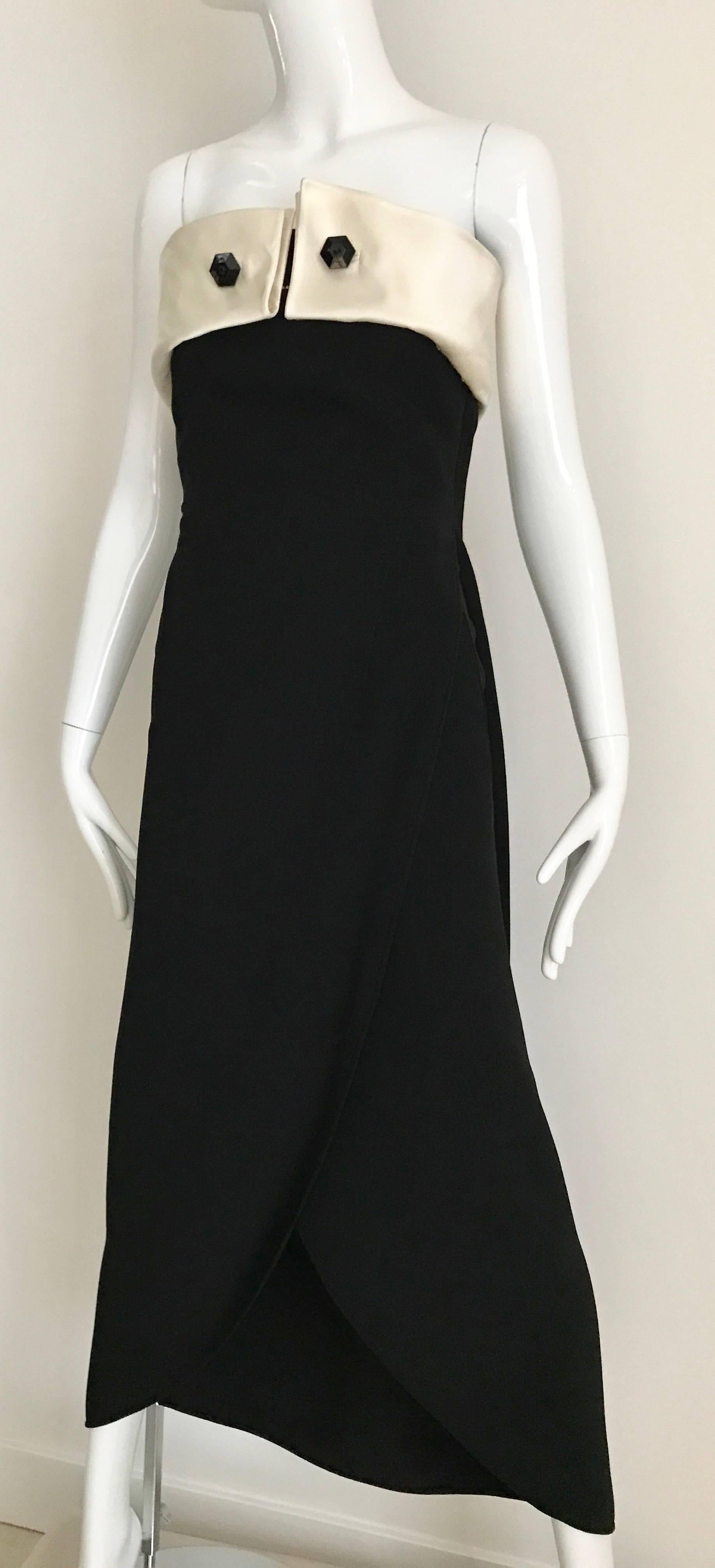Modern and Chic Vintage 90s Giorgio Armani Strapless Black dress with Creme Silk satin origami pleat bust. 2 Silk fold connected with black lacquer cufflink rhinestones chain. Dress has pockets and bustier zipper inside.
Perfect Gown for black tie