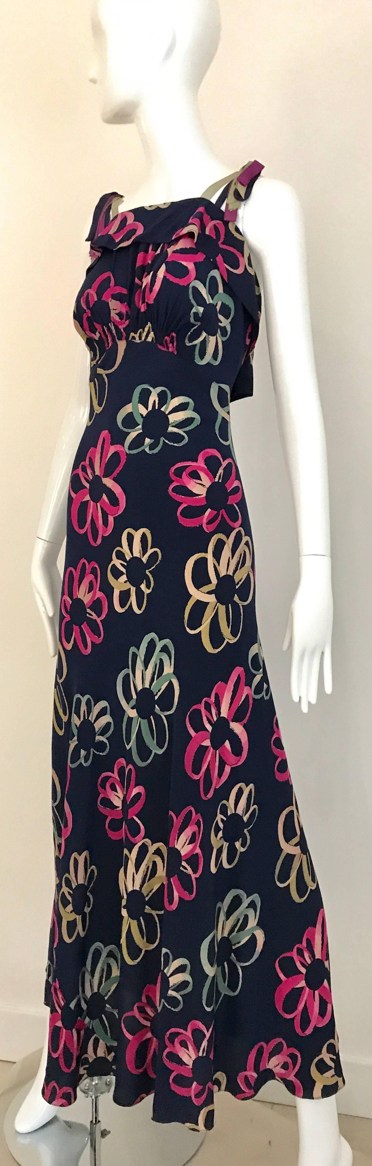 Flattering 1930s Bias Cut Blue, pink, green and yellow floral print silk dress. Spaghetti strap silk ribbon and bow at the back. Perfect for summer party dress. Silk still in excellent strong condition and wearable.
Fit Small - Medium
Bust: 36 inch