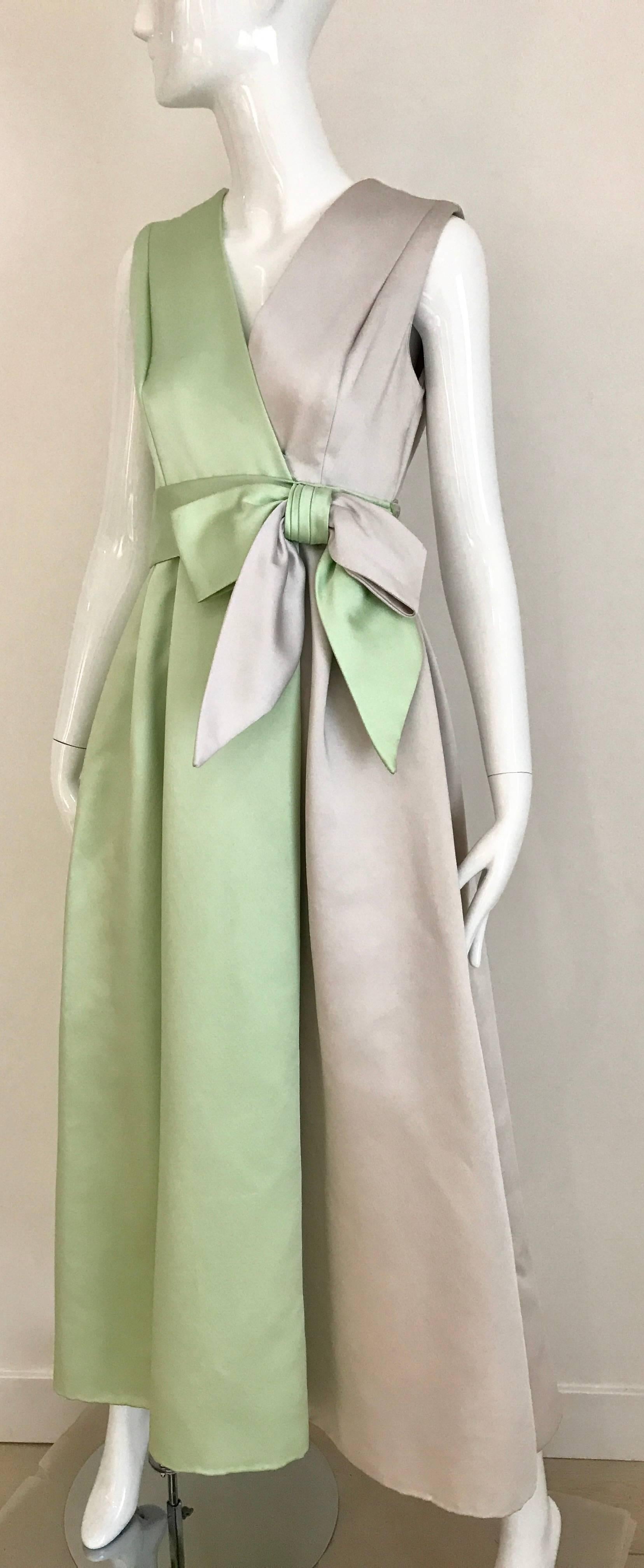 Vintage 60s Heavy Satin two tone green and light gray cocktail sleeveless dress with bow. V neck and Zip at the back. Snap button on the side. 
Size : 2/4 Small 
Bust: 34 inch / Waist 26 inch / 