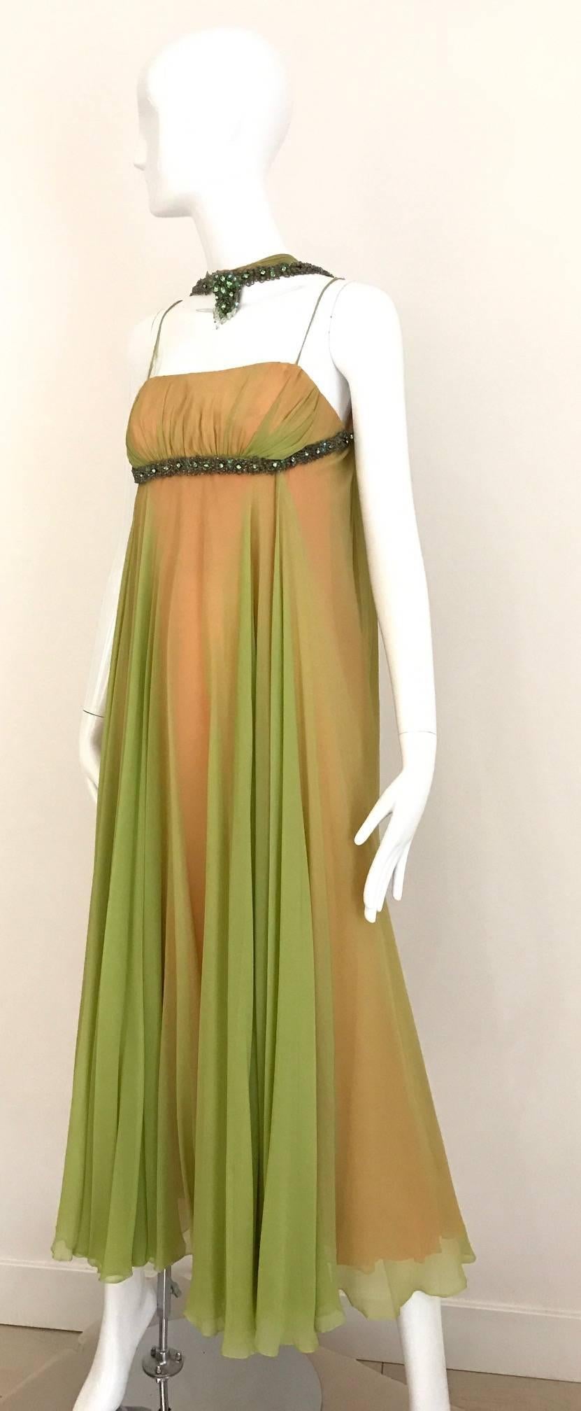 Beautiful Late 1950s and Early 1960s Silk Chiffon Gown in chartreuse  green with peach  Crepe lining. Gown has two spaghetti  straps and jeweled collar that connect from the back. Rhinestones beads underneath the bust line. 
Bust : 32 inch 
****