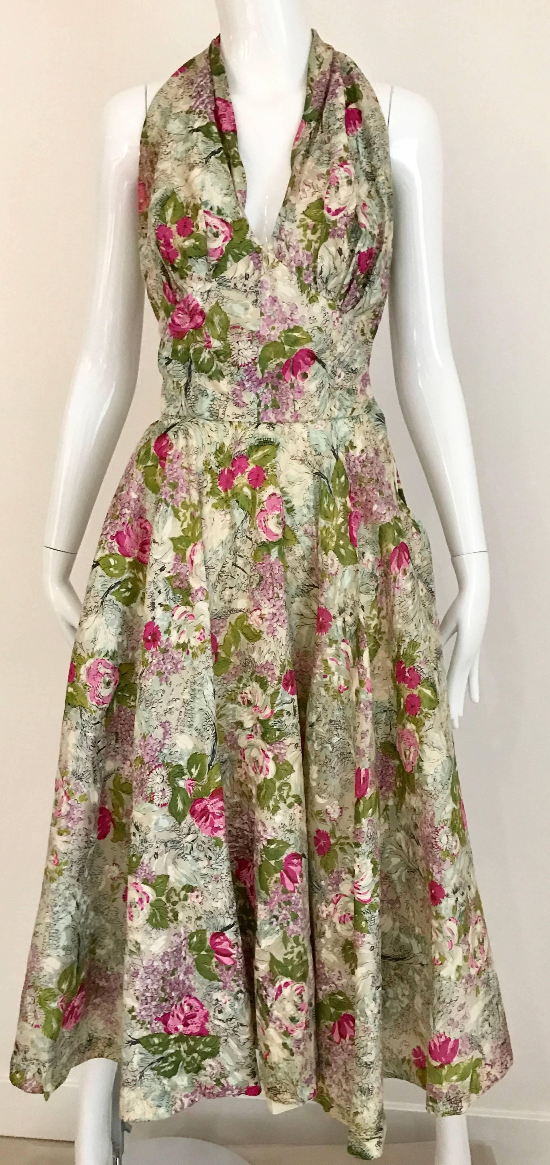 What a fabulous 1950s water color floral print in red, green and pink  vintage Halter Dress. V neck, nipped in the waist and skirt has crinoline to create fullness.  
Bust: 36 inch / Waist 26 inch/ Hip  open/ Dress length: 48 inch