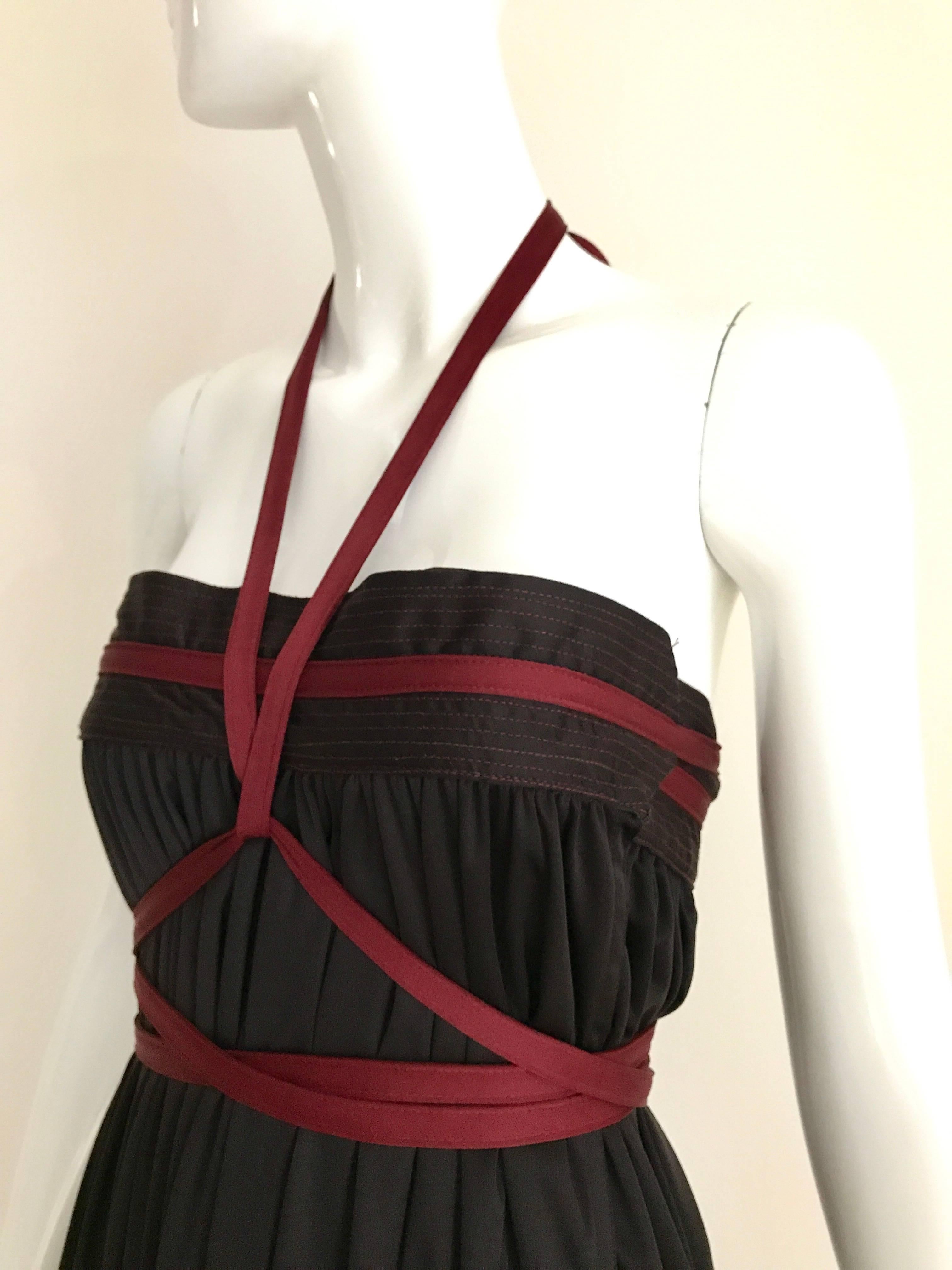 Vintage Geoffrey Beene Qiana Brown burgundy red knit strapless dress with long sash.  Dress can be worn as a maxi skirt. Dress has hidden pocket.
Skirt is styled with Gianfranco Ferre Knit top available at my 1stdibs store
Fit most sizes from