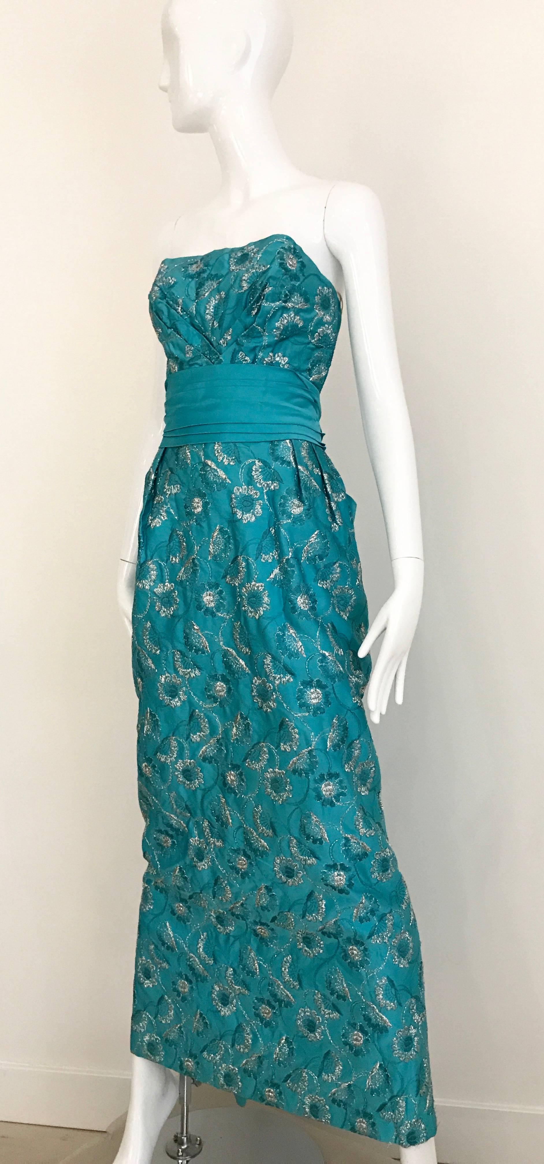 Classic Old Hollywood 1960s turquoise Silk Gown with silver floral Embroidered Gown with bow at the back. 
Size 4 
**This Gown is Great condition no holes or damaged. the only flaw is stains see images attached
