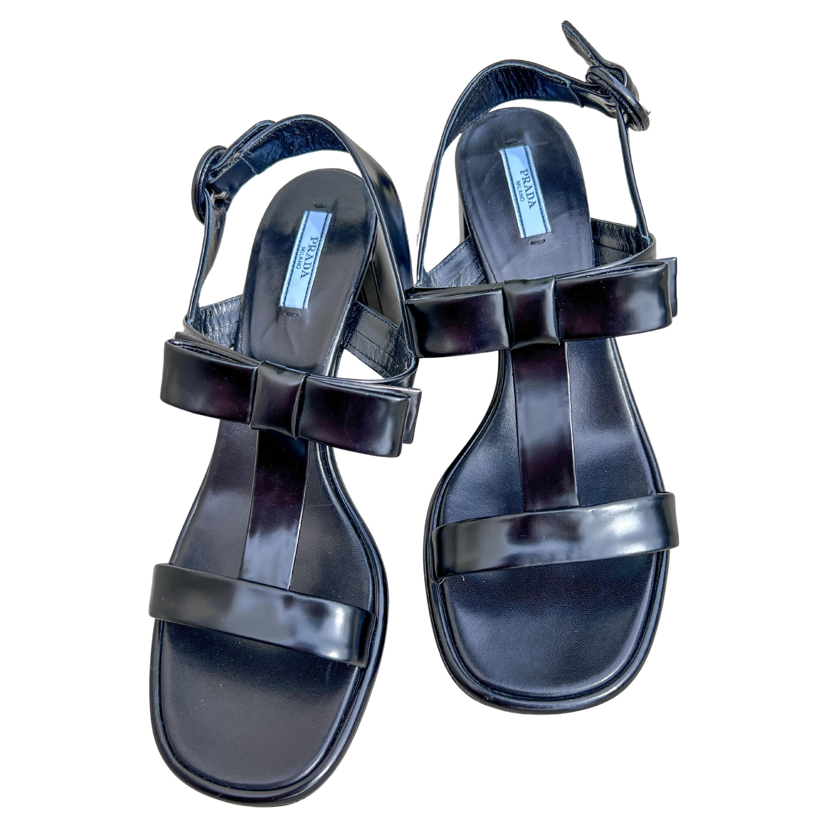 Un paio di sandali eleganti e scultorei della collezione primavera/estate 2013 di Prada, questi sandali in vernice nera riflettono la maestria di Miuccia Prada nel creare un minimalismo raffinato con un tocco. Caratterizzato da linee decise e pulite