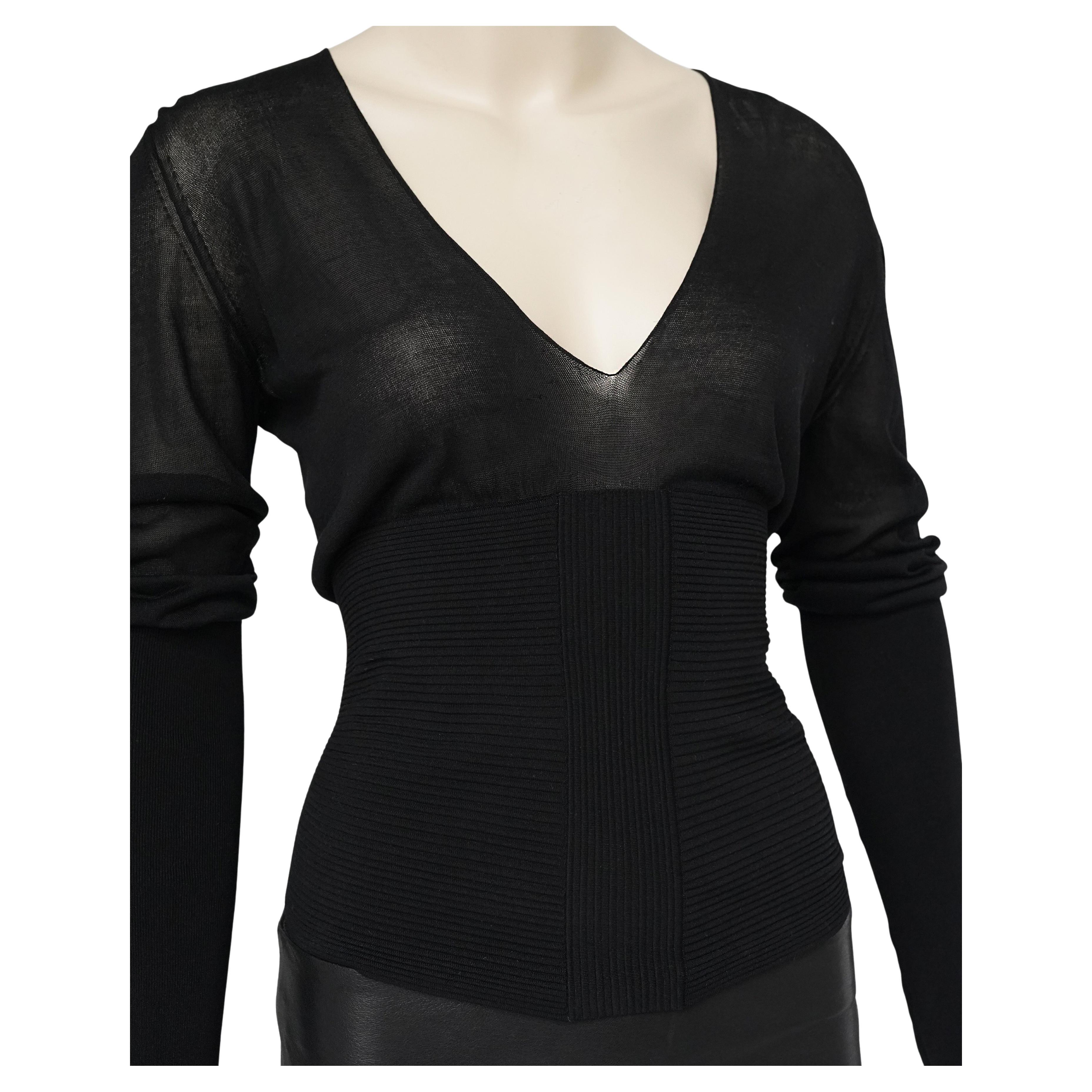 Un haut en maille, rare et saisissant, conçu par Tom Ford pour Gucci, datant du début des années 2000. Cette pièce noire à manches longues est réalisée en soie mélangée transparente et présente un décolleté en V profond, des manches allongées et une