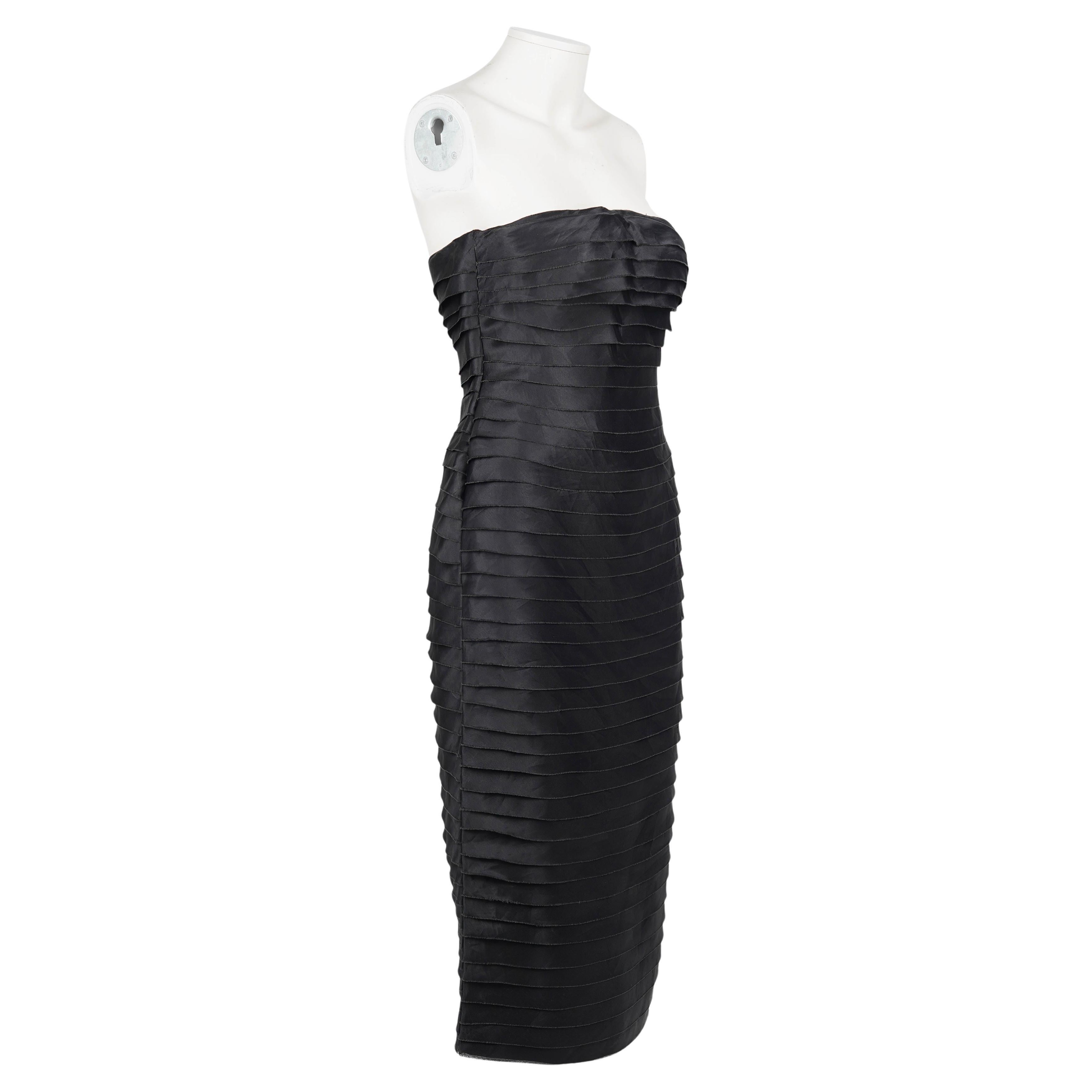 Dieses ikonische und seltene Stück aus Tom Fords Frühjahr/Sommer-Kollektion 2001 für Gucci ist ein auffälliges trägerloses Cocktailkleid, das vollständig aus horizontalen Bändern aus schimmernder schwarzer Seide gefertigt ist, die kunstvoll
