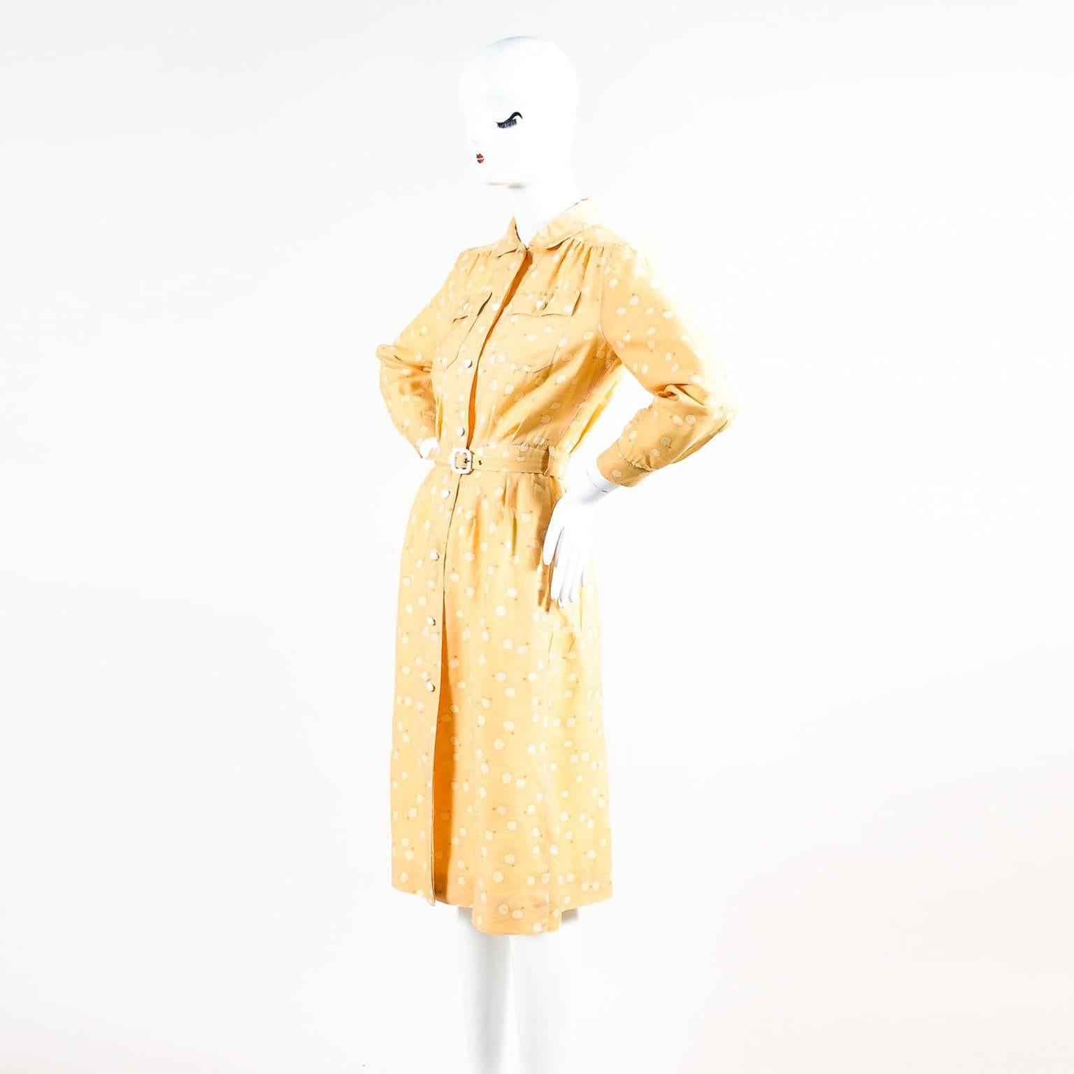This feminine shirt dress from Courreges features a fitted silhouette with long sleeves. Front white button fastening with a pointed flat collar. Constructed of muted yellow and cream abstract cloud-like print throughout. 
Single button cuffs with