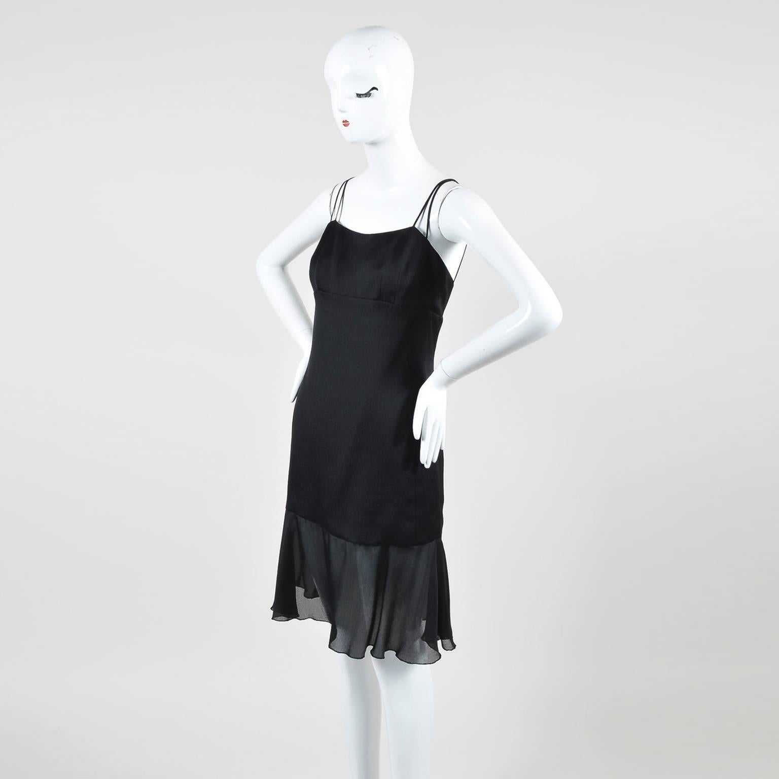 This black silk dress is finished with a chiffon ruffle hem. There are three spaghetti straps on each shoulder that meet at a 'CC' logo button in back. Zip closure down back. Lined.