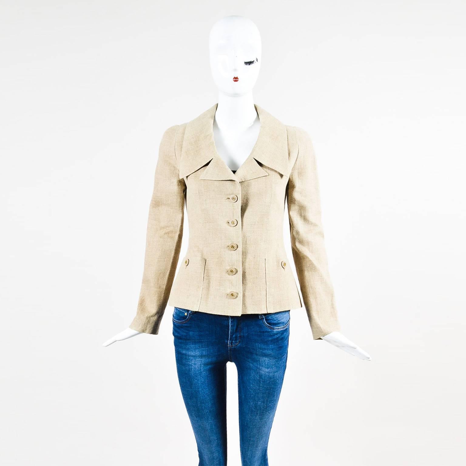 Chanel tan linen jacket has button closure down front, each detailed with a gold tone 'CC' logo. Long sleeves have padded shoulders and button closure at the openings. Two pockets. Two short slits in back. Silk lined. From the Spring 1994