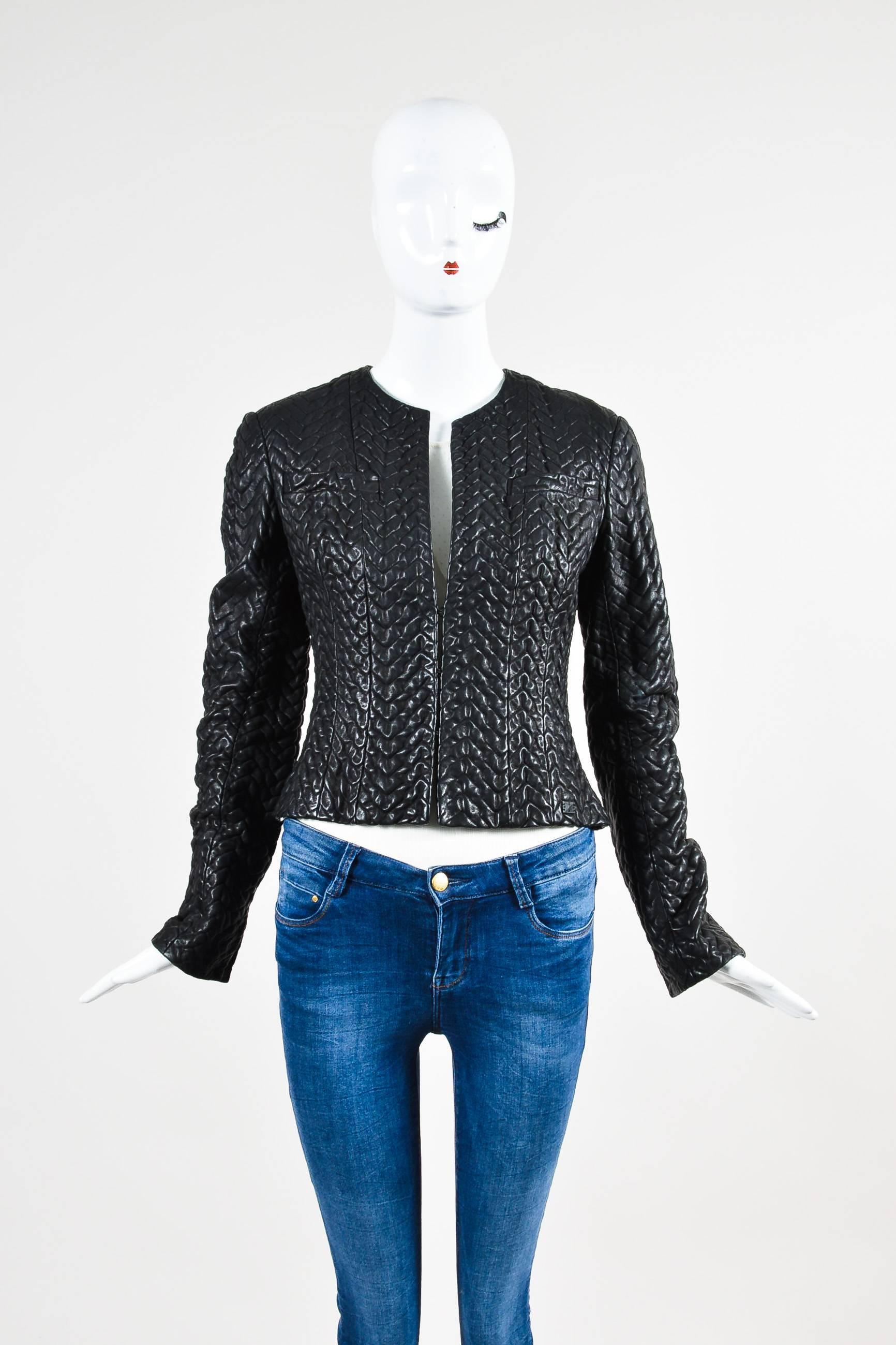 Retails at $3865. Black long sleeve textured leather Chanel cropped jacket featuring two chest pockets and slits at sleeve openings. Three hook and bar closures. Lined.

Additional Measurements:
Sleeve Length: 25