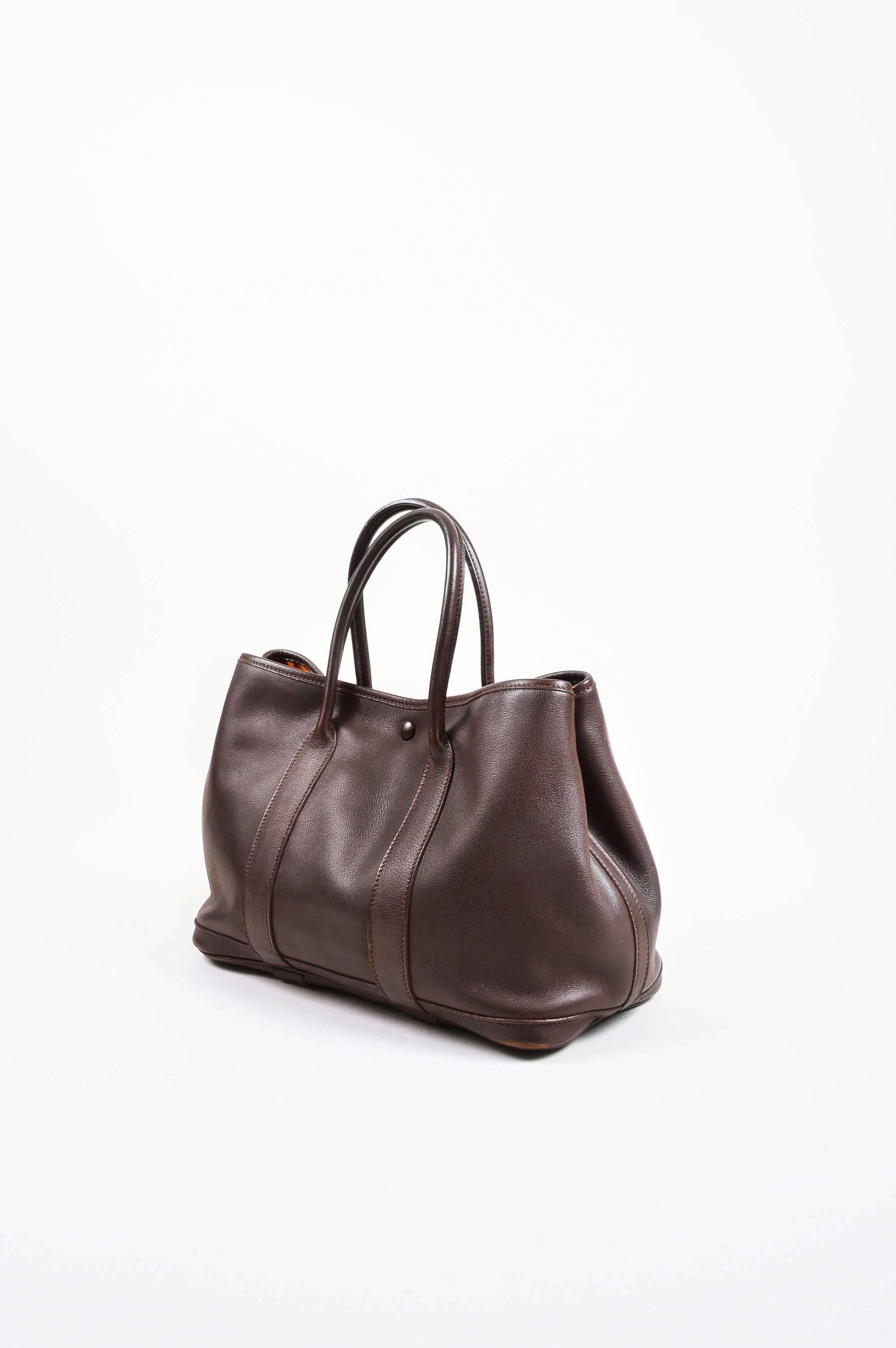 Sleek and versatile purse by Hermes that is perfect for daily use. The "Garden Party TPM" tote is a great size and shape to hold all of your essentials, including a large smart phone, long wallet, and even a small agenda. Brown,