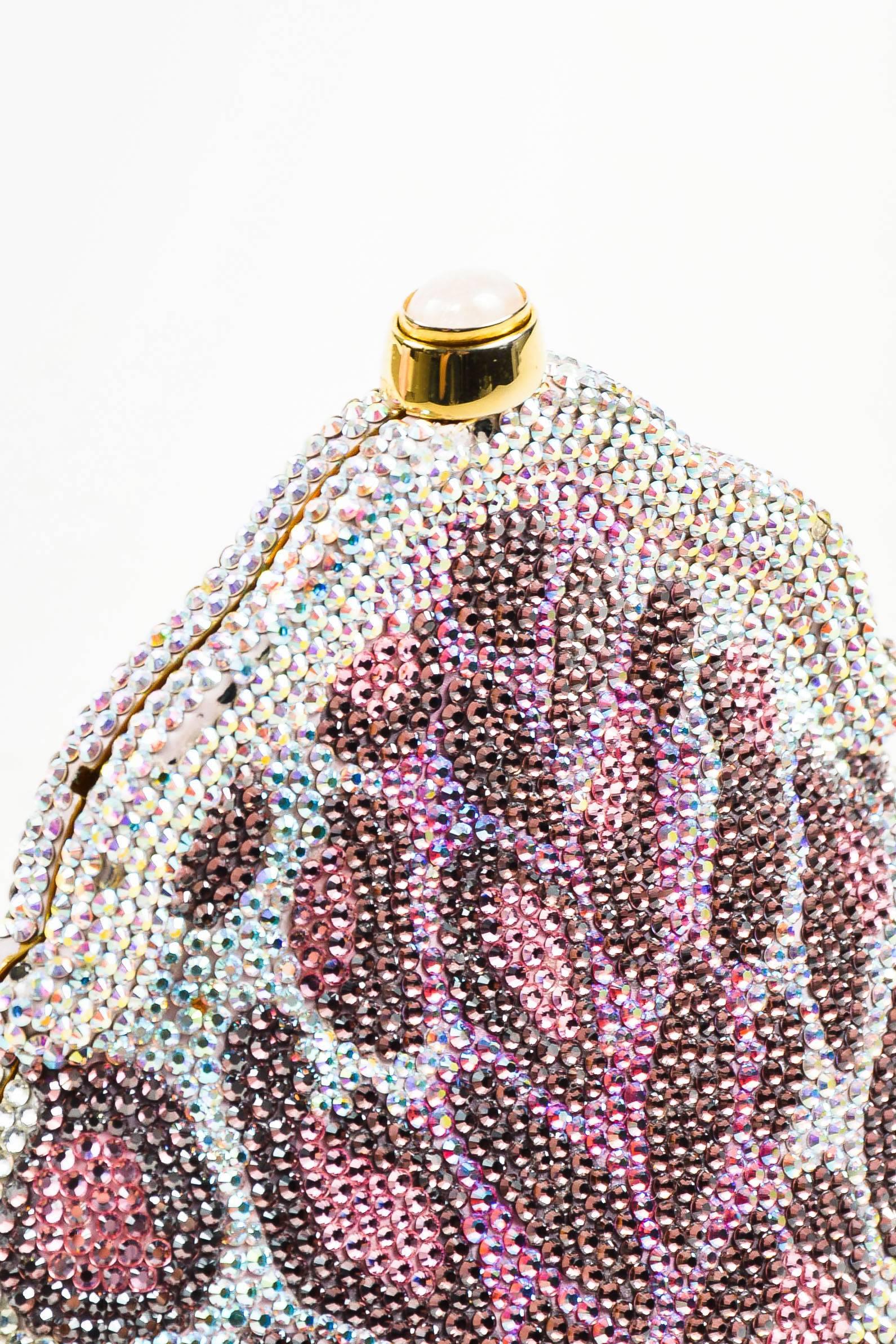 Eye-catching bag by Judith Leiber in a pink, purple, and clear rhinestone design. Leopard print with a curved shape. A great conversation piece for your next event. Frame style with hard sides and a top push lock closure. Chain folds out so the bag