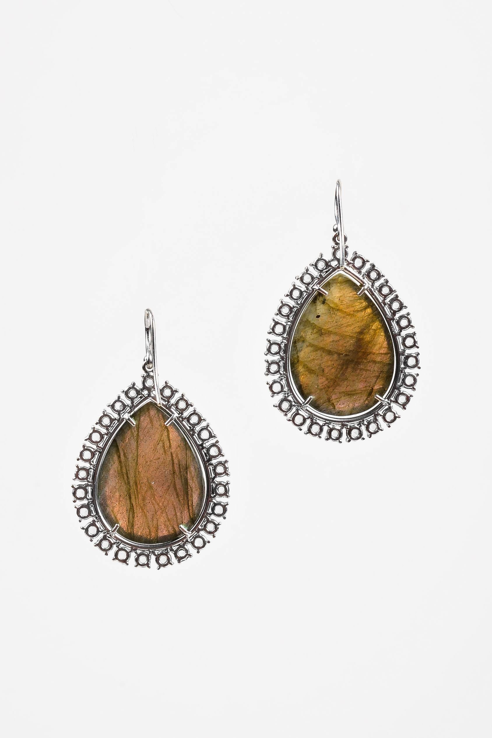 Retails at $24,140. These gorgeous drop earrings from Irene Neuwirth are constructed of a shimmering iridescent green rose-cut labradorite teardrop outlined in pave diamonds and framed in rose-cut diamonds that total approximately 5.6 carats. French