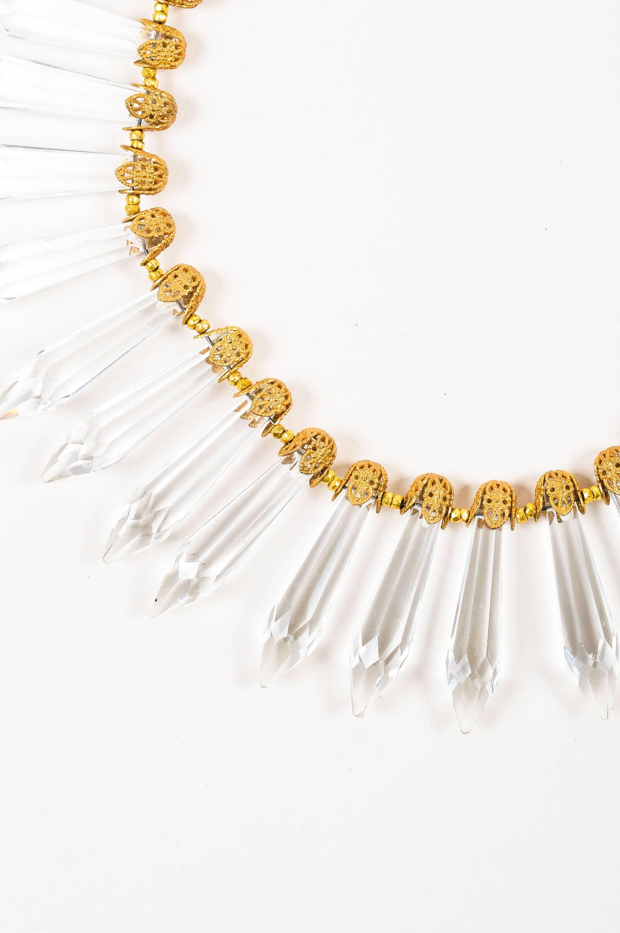 This striking vintage collar necklace is a rare collector's item and sparkling treasure in any jewelry box. Wear on a bare décolletage to let the beautiful design take center stage. Antiqued gold tone openwork end caps hold glass crystal spikes.