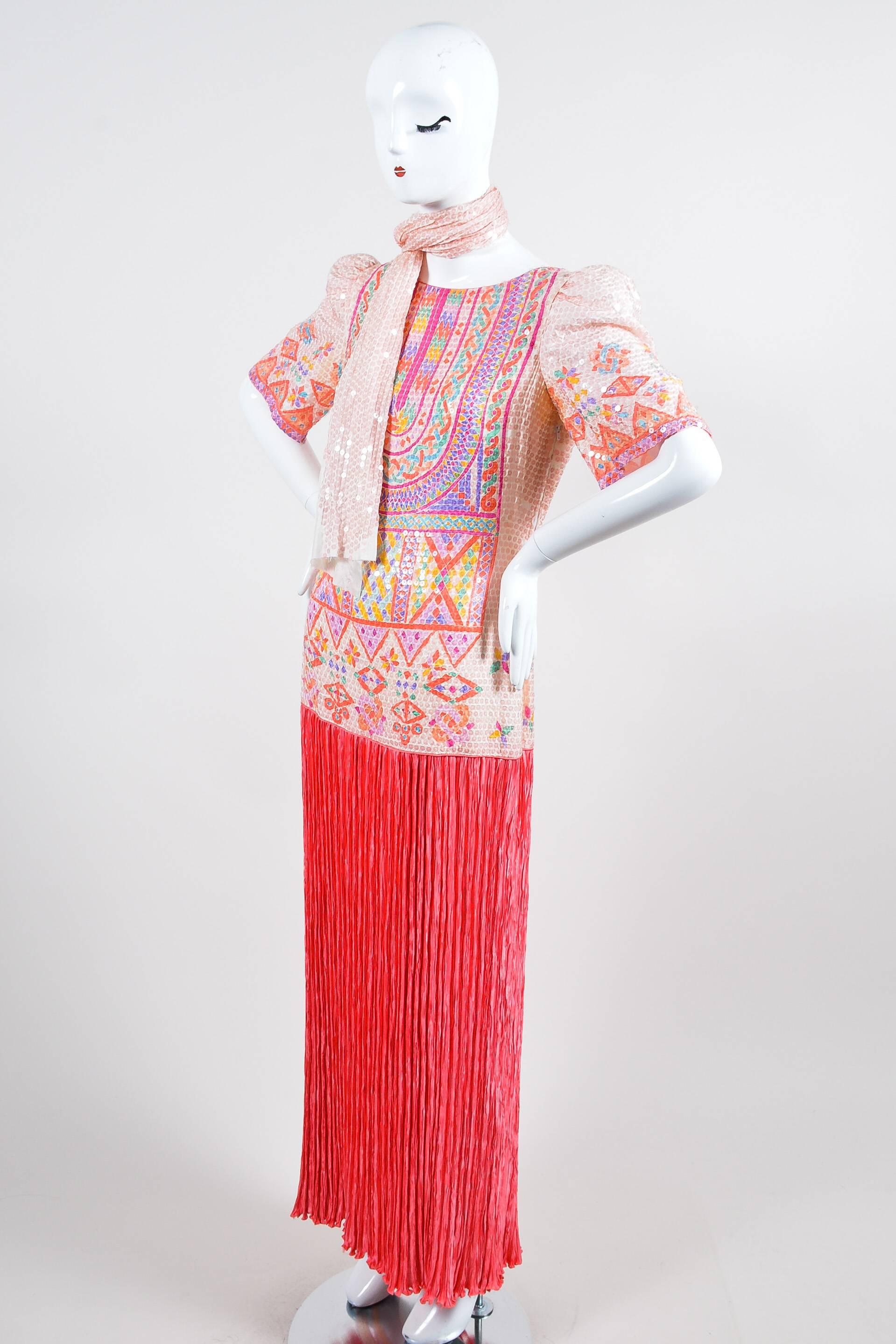 Bright and colorful vintage dress by Mary McFadden with allover sequin detailing. Coral, pink, purple, blue, yellow, and green pops throughout the geometric pattern. Micro pleated bottom in a deeper pink shade. Round boatneck collar with pink