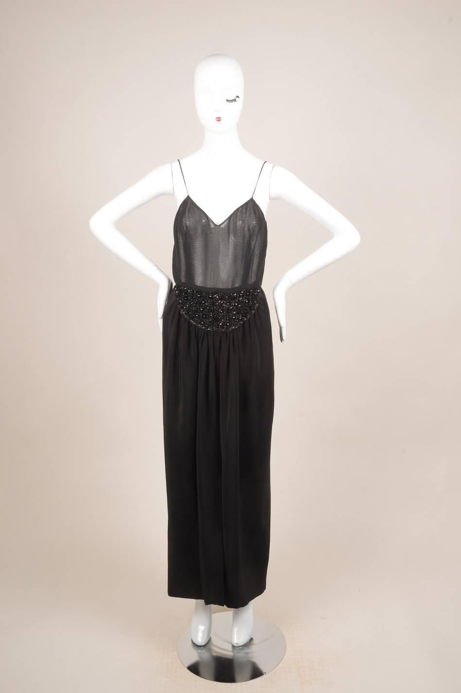 This embellished sleeveless dress features a v-neckline. Hits below knees.
Beaded embellishment on front skirt. Pleated skirt with a front slit. Hidden back zip closure with hook-and-eye closure. Sheer top. Partially lined

Additional