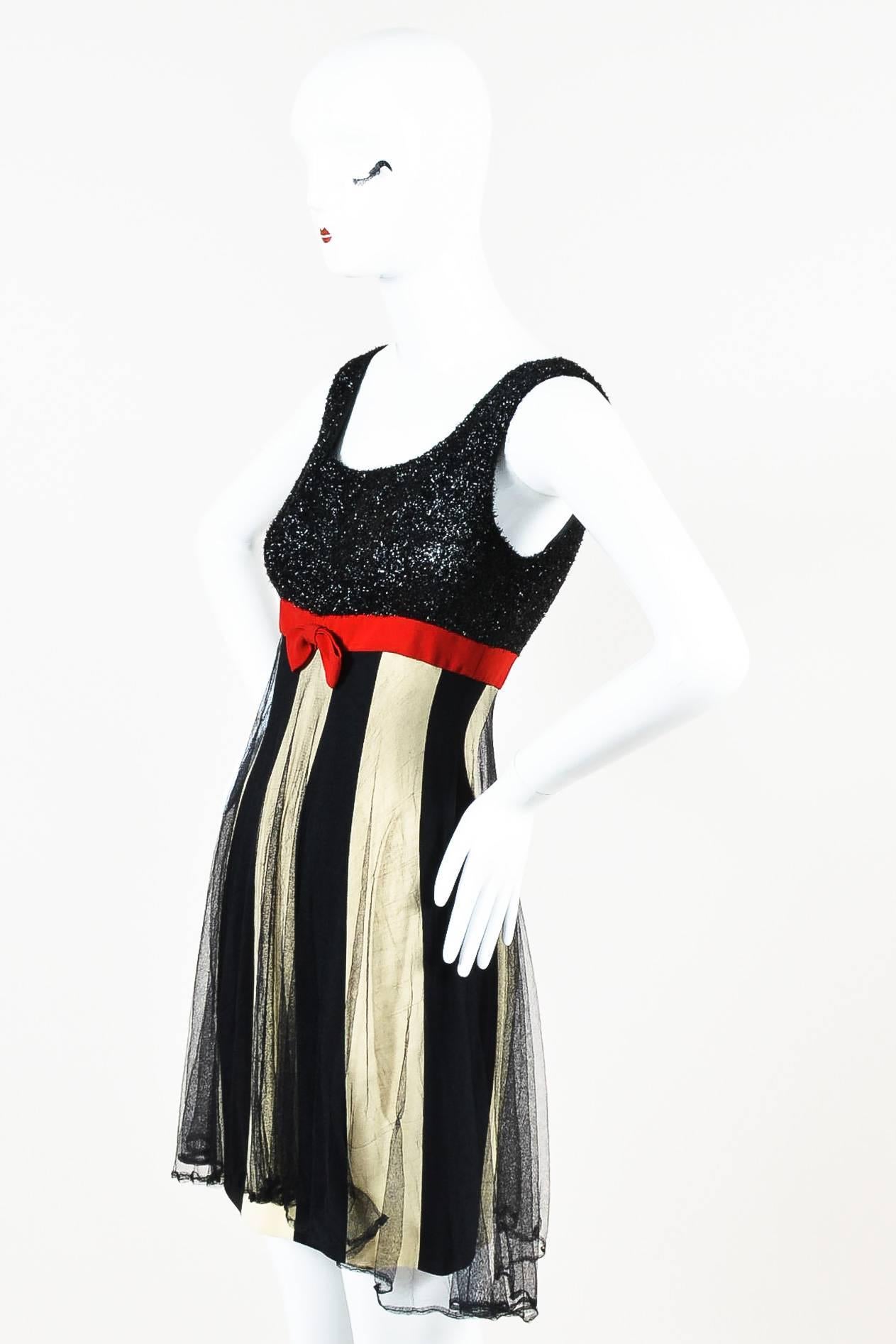 Vintage Moschino Couture black and cream stripe layered dress featuring a black metallic sleeveless bodice, red trim with bow at waist, and mesh overlay. Hidden back zip closure. Partially lined.

Condition: Pre-owned. This item is in good