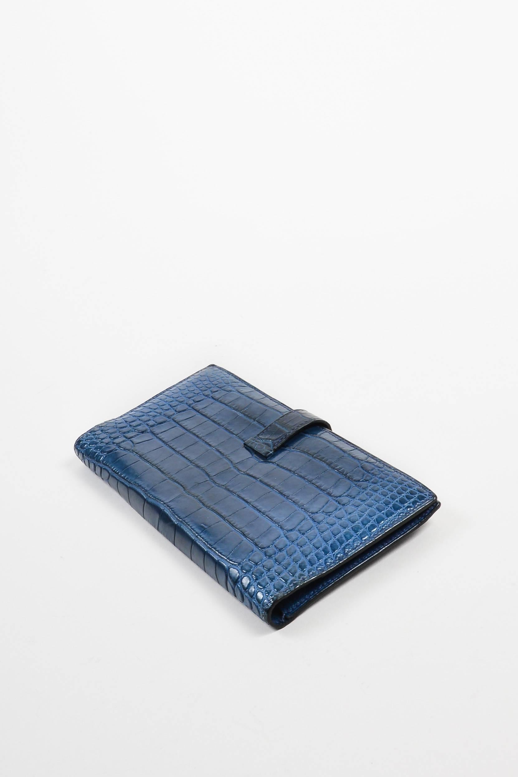 Rich, marine blue genuine alligator leather wallet from Hermes. Palladium-plated silver-tone 'H' hardware at front; leather tab slips through hardware for closure. Leather-lined interior. Date code: [F] 25A. Comes in box. 

Interior Features: