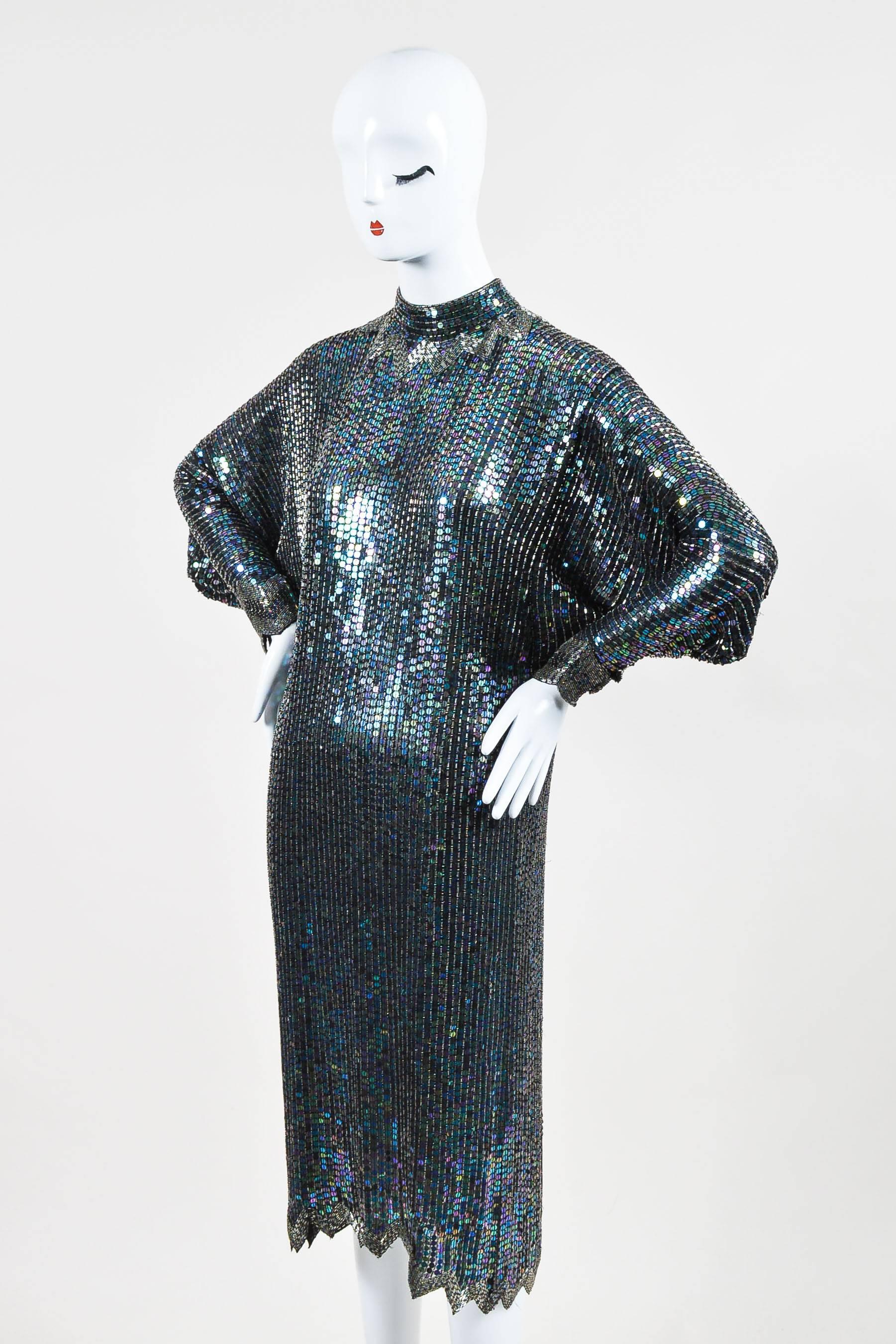 Showstopping vintage dress that oozes classic Halston glam. Sheer textile construction. Bold iridescent sequin and beaded embellishment throughout. High collar. Patterned beaded border trimmings. Scalloped hem. Long dolman sleeves. Hits below knees.
