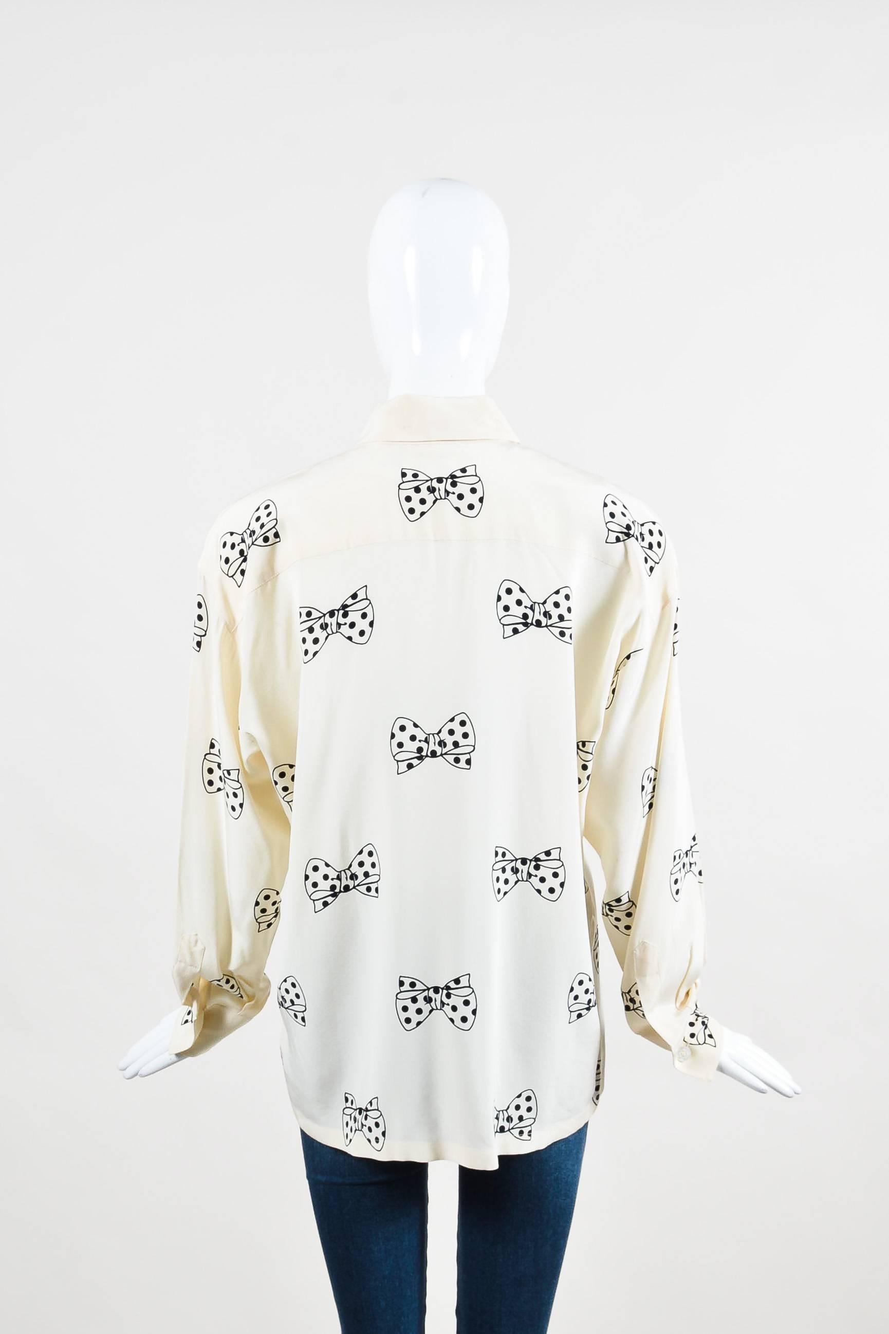 Vintage cream silk blouse with polka dot bow print. Semi-sheer. Long sleeves with buttoned cuffs. Point collar. Light shoulder padding. Buttons up front. Unlined.

Additional Measurements: 
Sleeve Length: 21.5